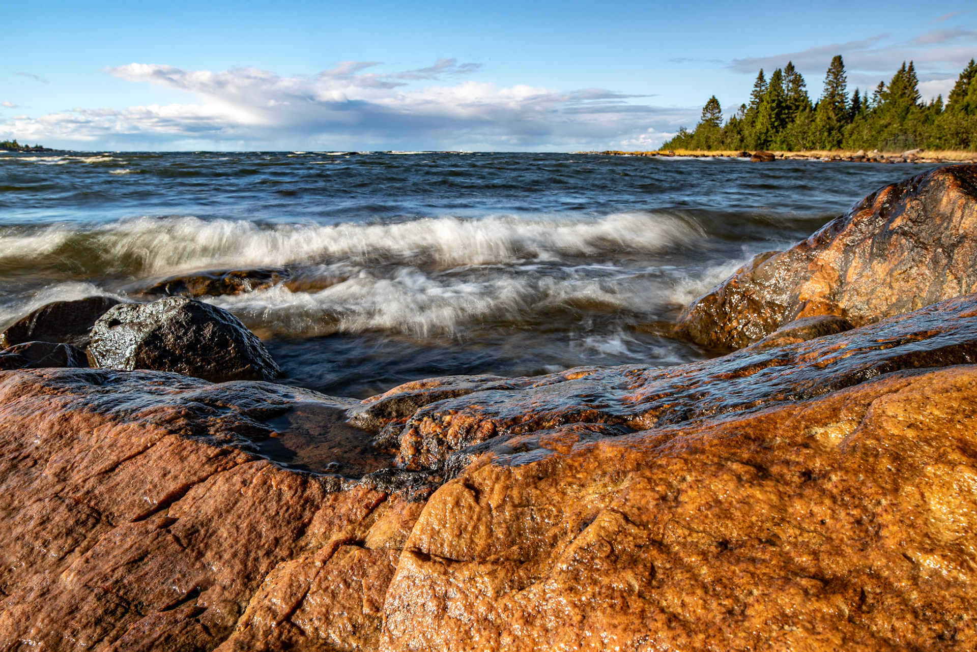 Waves and wet rocks a sunny and stormy day by the sea in the Bothnian Sea, Sweden.