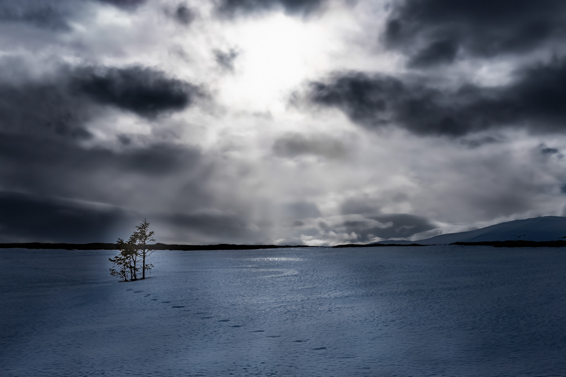 Bad weather is approaching in the blue hour. Dramatic sky in the mountains of Ullådalen, Åre in Sweden. Animal tracks in the snow.