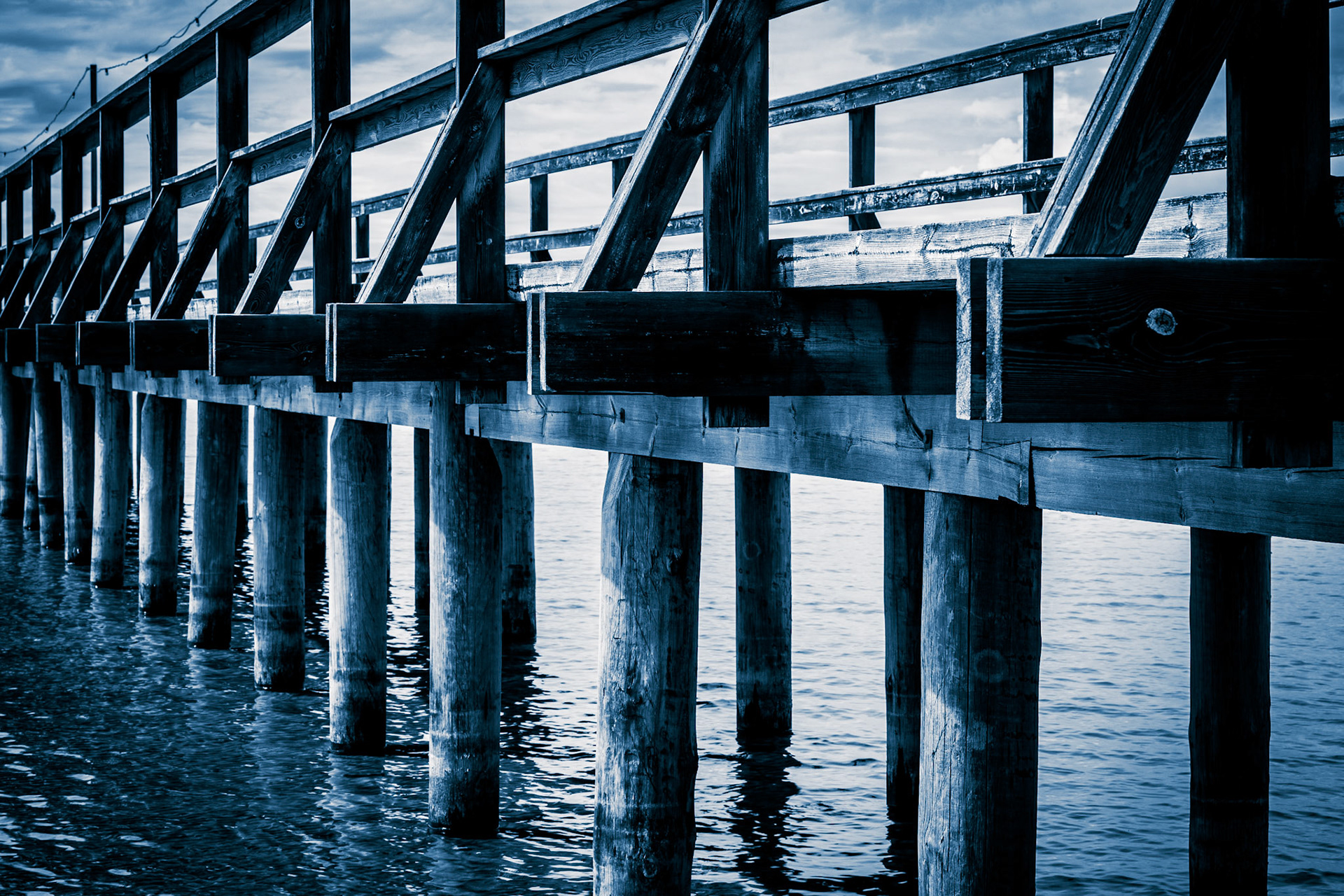 Wooden pilings and wooden railing in the bridge in Rättvik, Sweden The long bridge (Långbryggan) in Rättvik is Sweden's longest lake bridge and is one of the world's longest wooden structures. The image was taken in July 2024.