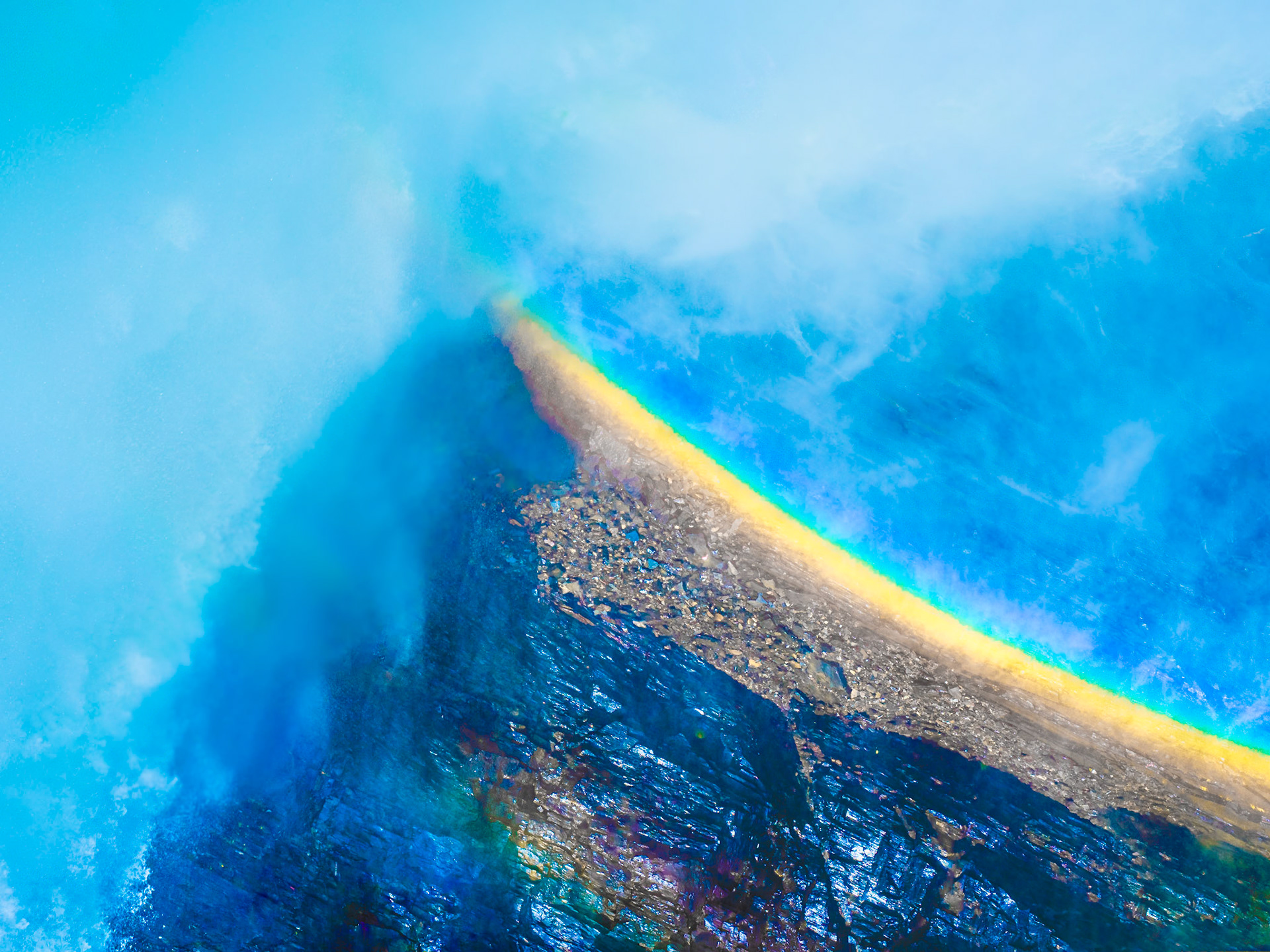 Waterfall in Tännforsen, Sweden, and rainbow in the water. The photo was taken in the middle of the waterfall in July 2023. Tännforsen is Sweden’s largest waterfall, twenty kilometers west of Åre, the water drops almost 40 meters down to a lake, creating a 60-meter wide rushing wall that is a spectacle for many senses at all times of the year.