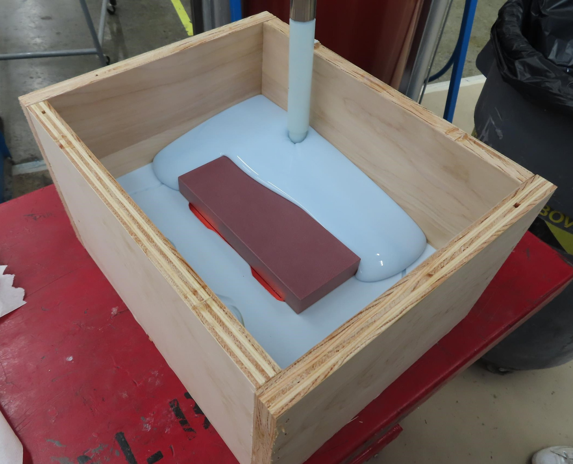 For the second half of the mold, I placed an MDF panel against the base of the upside down car. This would be used to hold the flowers in place during the curing process. For the first pour I used a panel of acrylic so I could see through it while I was arranging the flowers but for the remainder of the pours I used MDF so I could use the top half of the mold.