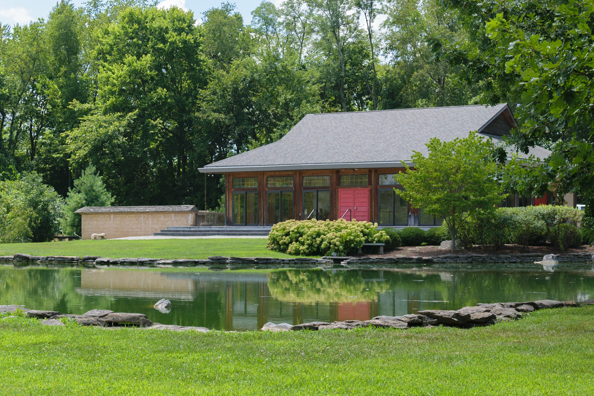 This Japanese style building rests on the other side of the pond in the garden.
