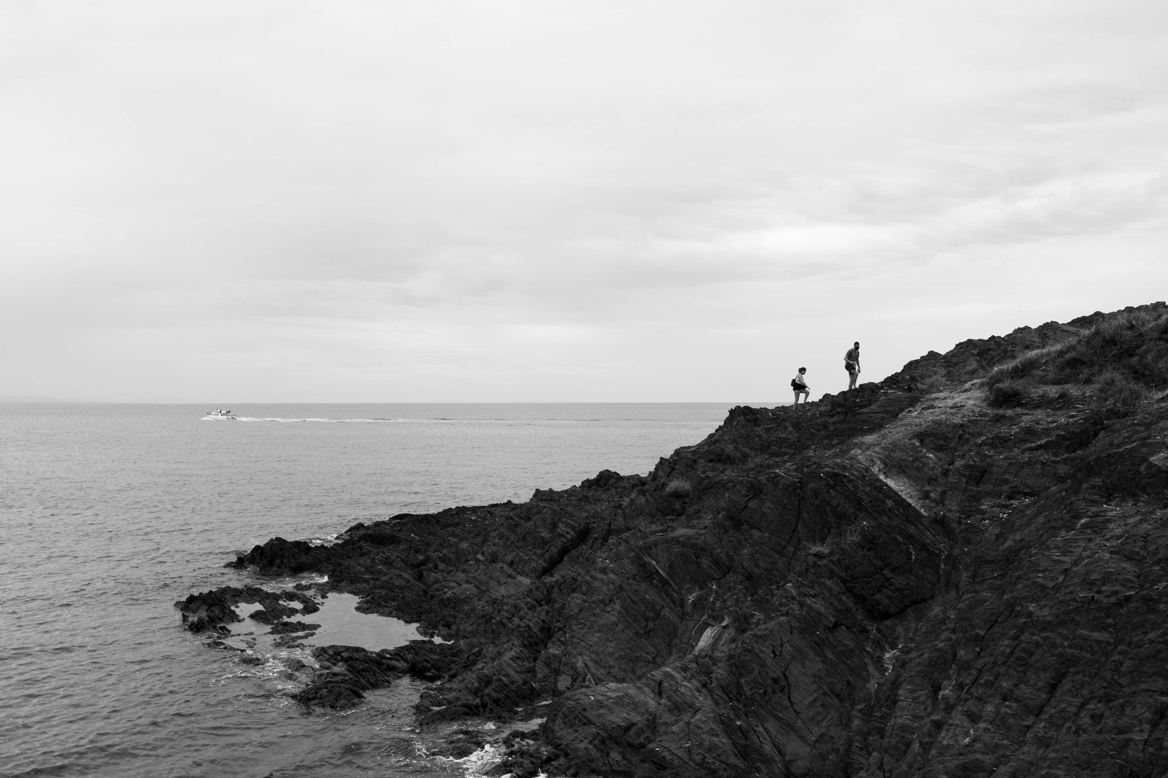 Two people climbing a cliff in Collioure