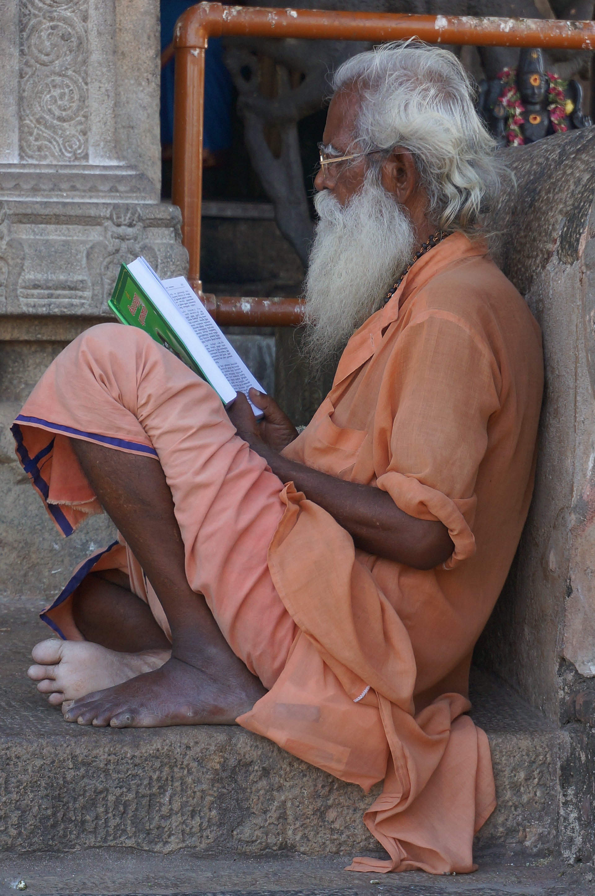 Man reading on the stairs of a temple in Thanjavur, Tamil Nadu