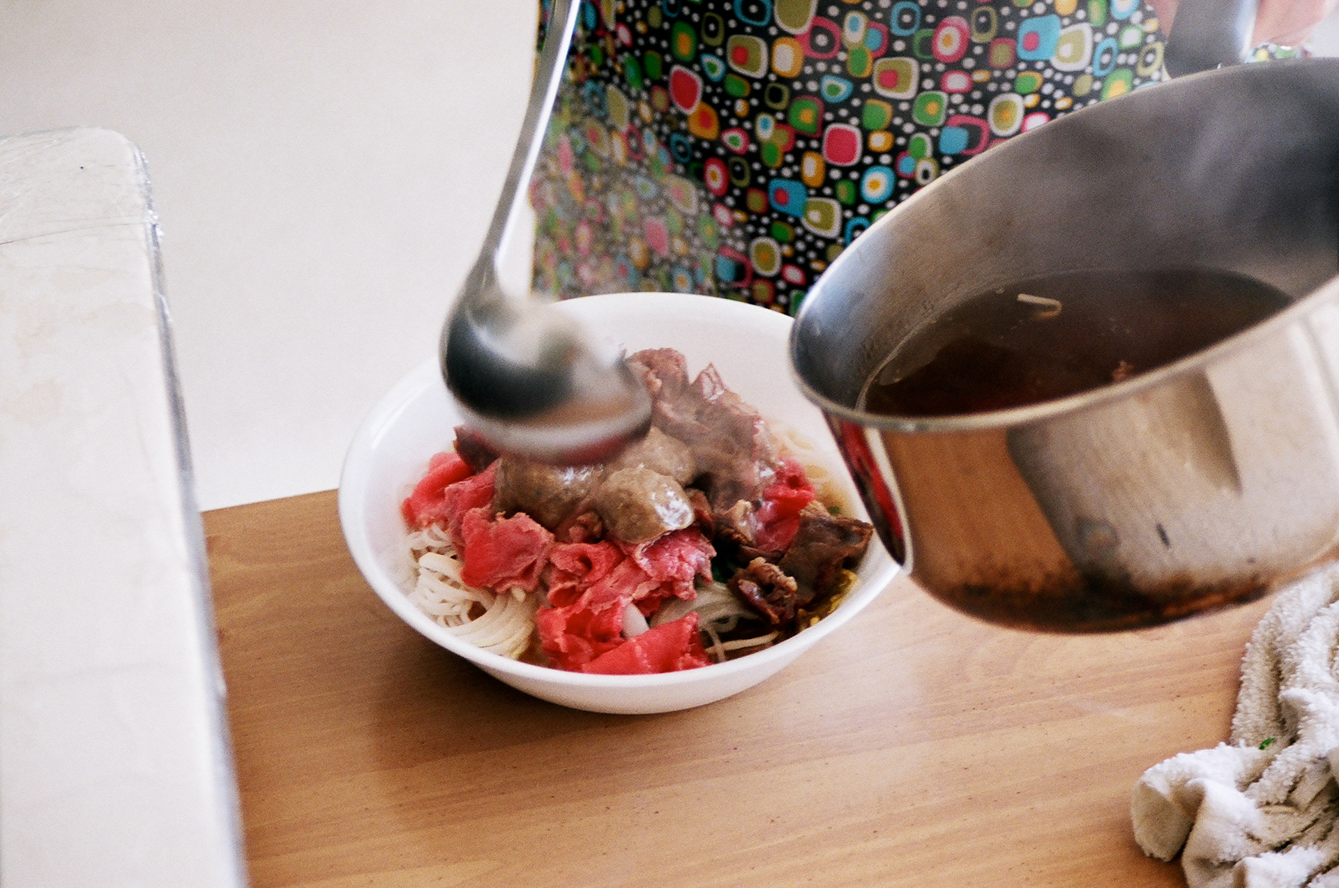 The broth is poured over the thinly sliced round eye steak, which sears it to perfection.