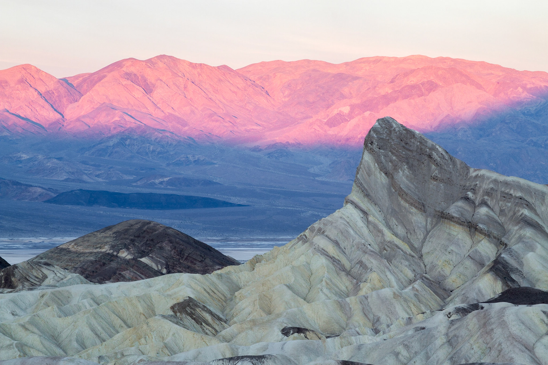 Early morning light lighting up the mountains behind the Manly Beacon at the Death Valley National Park.