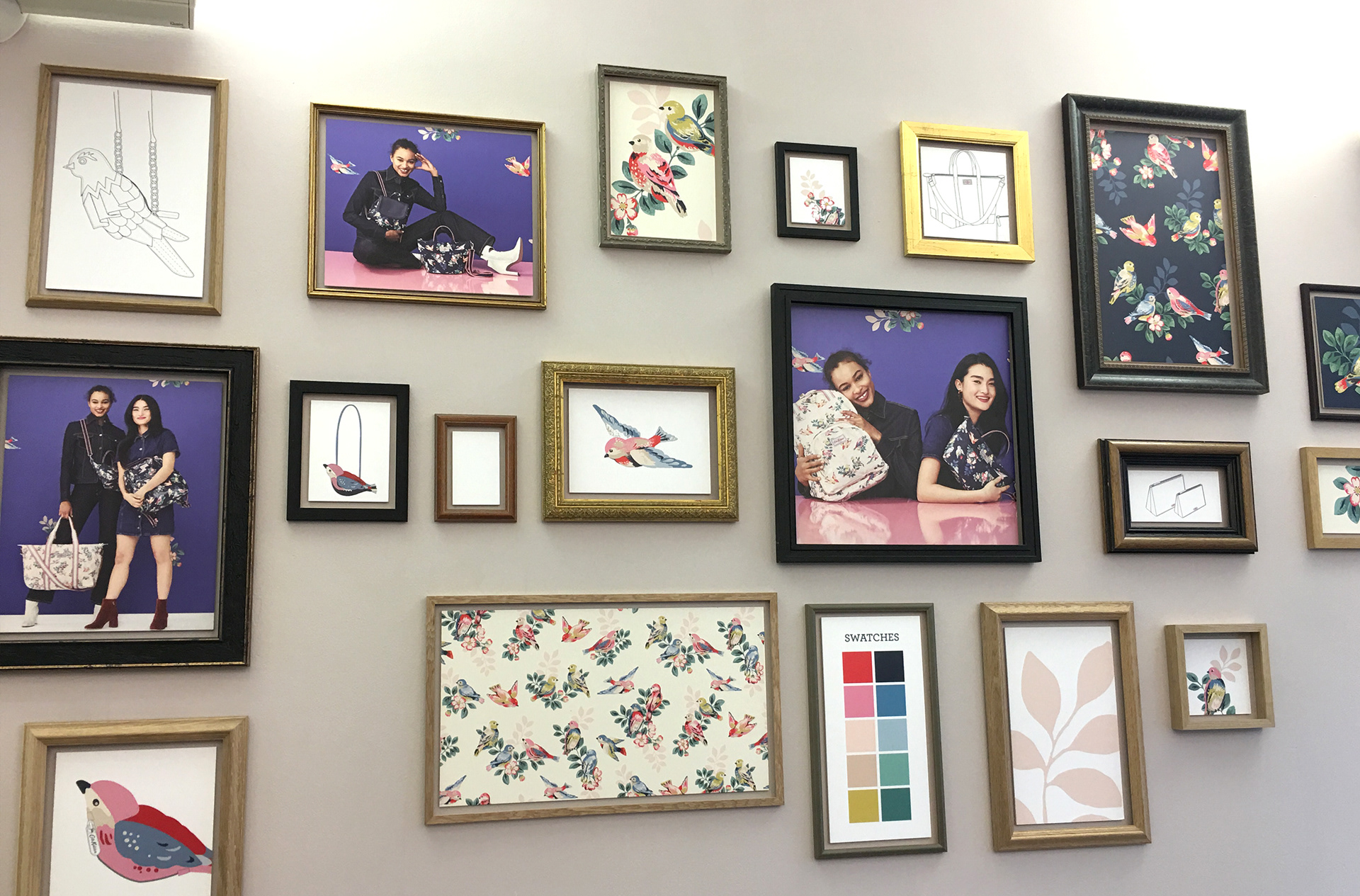 CK London office reception wall of framed prints of handbag range & print patterns