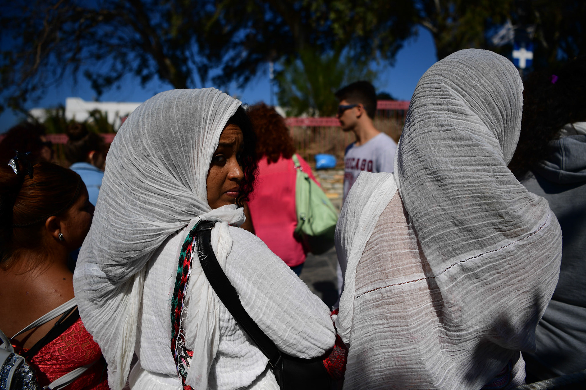 Ethiopian pilgrims wait during the Ascension of Virgin Mary holiday, in Tinos, Greece, Wednesday, Aug. 15, 2018.