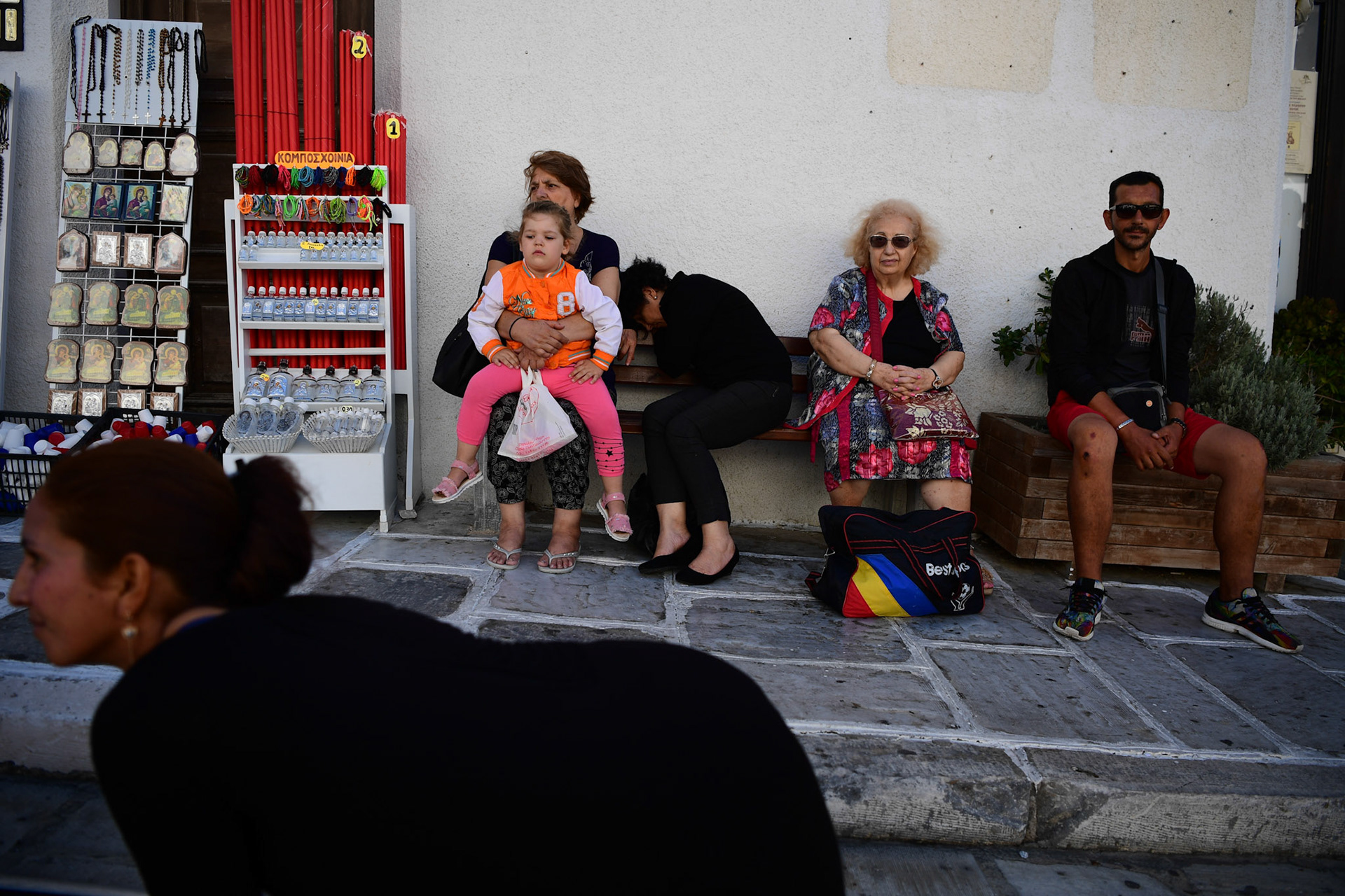 People watch a pilgrim as she crawls her way to the Greek Orthodox Church of Panagia Evaggelistria during the Ascension of Virgin Mary holiday, in Tinos, Greece, Wednesday, Aug. 15, 2018.