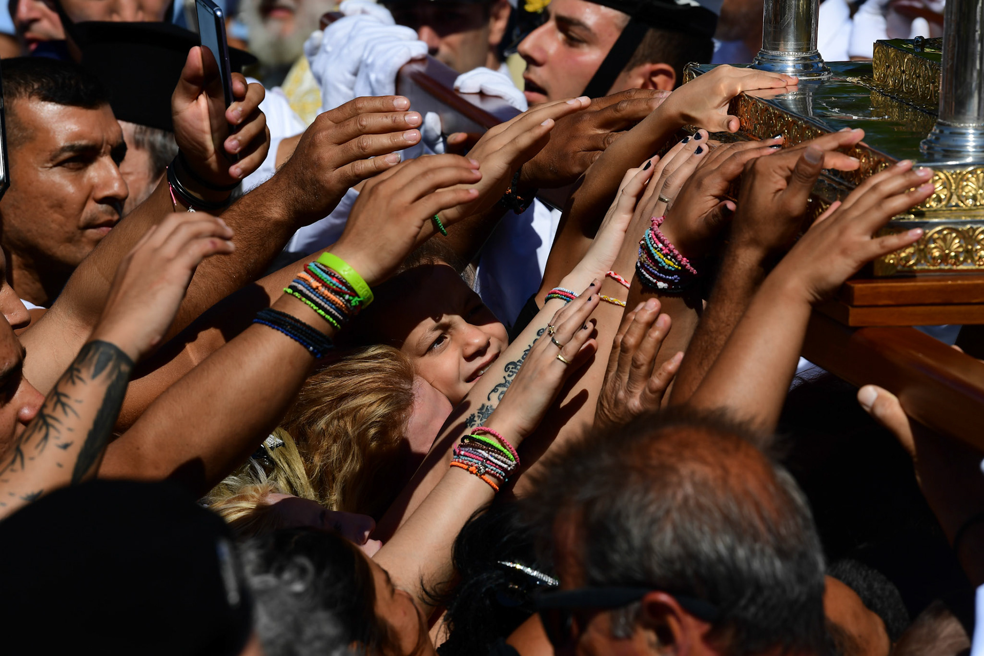 Pilgrims try to reach the Holy Icon of Panagia during the Ascension of Virgin Mary holiday, in Tinos, Greece, Wednesday, Aug. 15, 2018.