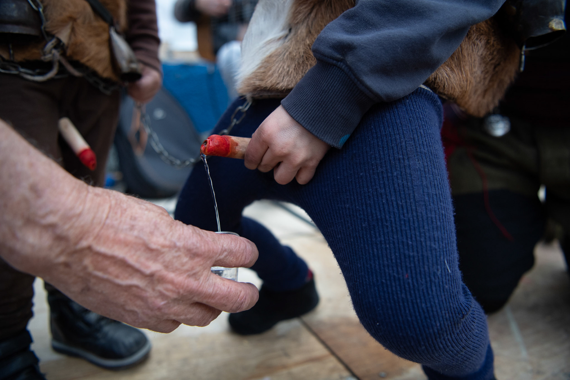 A child dressed as a satire pours raki, the traditional drink of Crete, in a cup, at the festivities of Clean Monday, in the village of Yeryeri, Crete, Greece, Monday, Feb. 27, 2017.