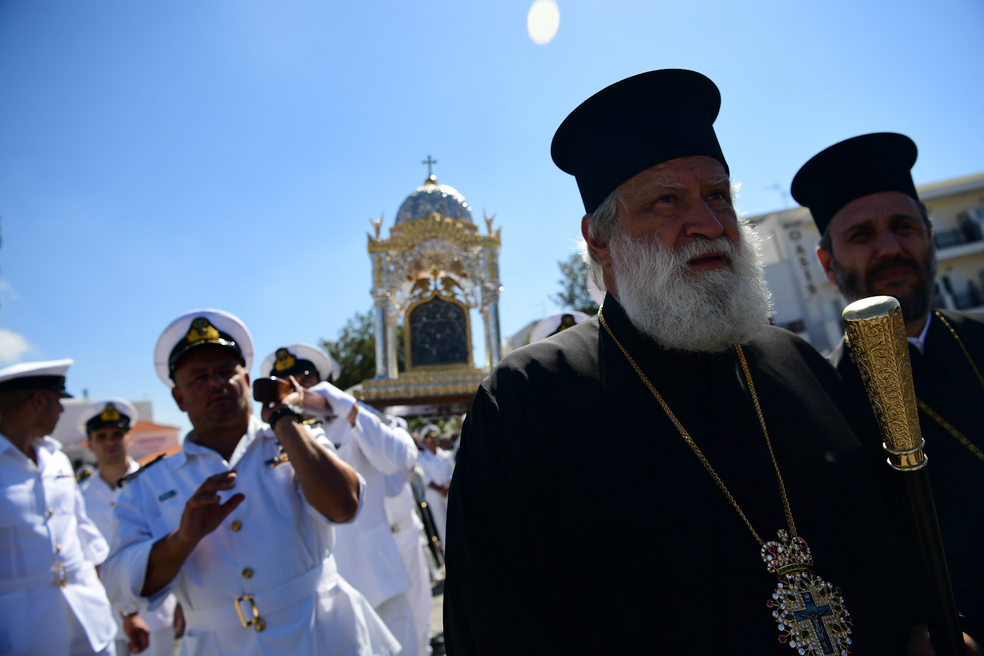 A Greek Orthodox priest accompanies the Holy Icon of Panagia, during the Ascension of Virgin Mary holiday, in Tinos, Greece, Wednesday, Aug. 15, 2018.