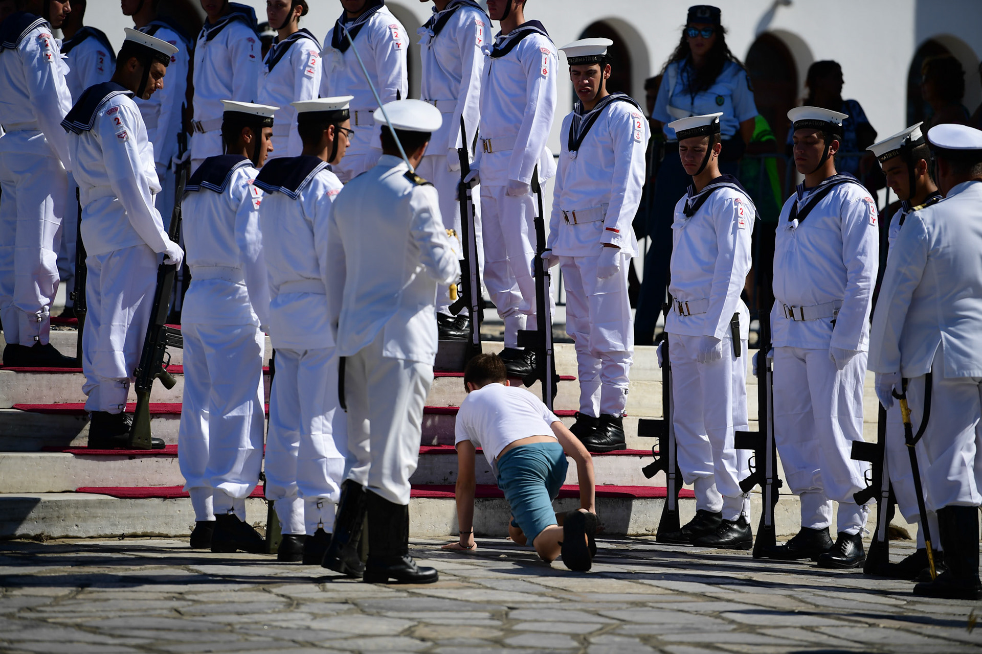 A young pilgrim crawls his way to the Greek Orthodox Church of Panagia Evaggelistria among Greek Navy personnel during the Ascension of Virgin Mary holiday, in Tinos, Greece, Wednesday, Aug. 15, 2018.
