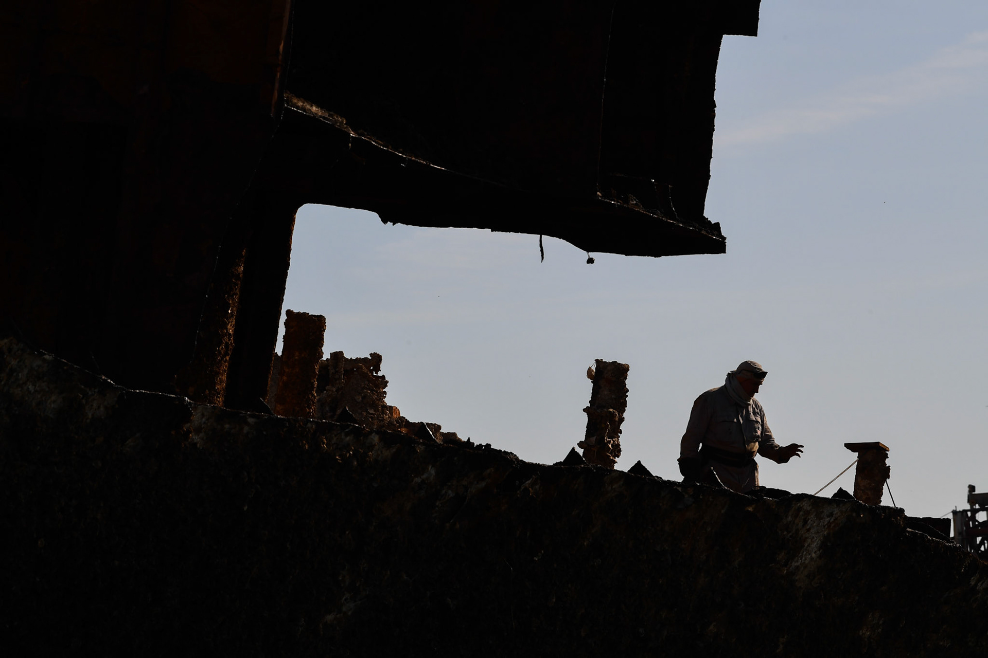 A shipyard worker performs operations on the “Corfu Island” shipwreck, in the town Perama, west of Athens, Greece, Friday, Nov. 2, 2018.