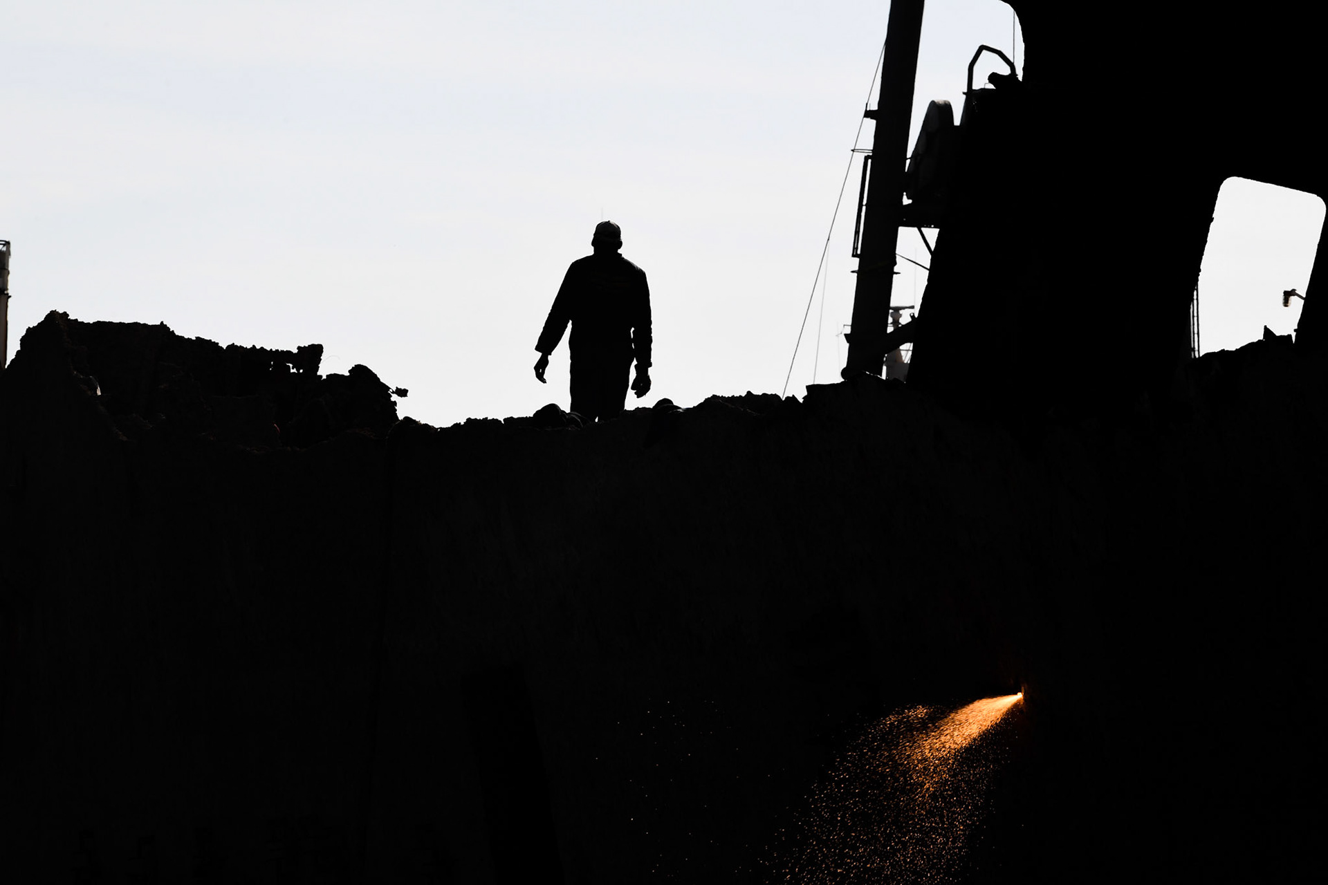 A shipyard worker walks on the “Corfu Island” shipwreck, in the town Perama, west of Athens, Greece, Friday, Nov. 2, 2018.