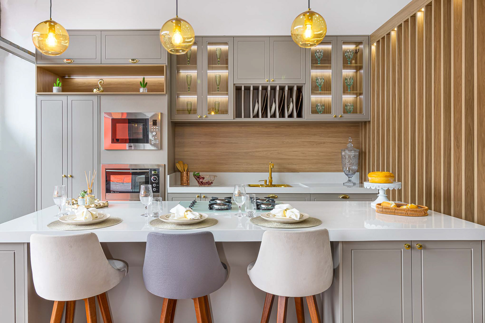 Fotografia de cozinha planejada com ilha, vista de frete.