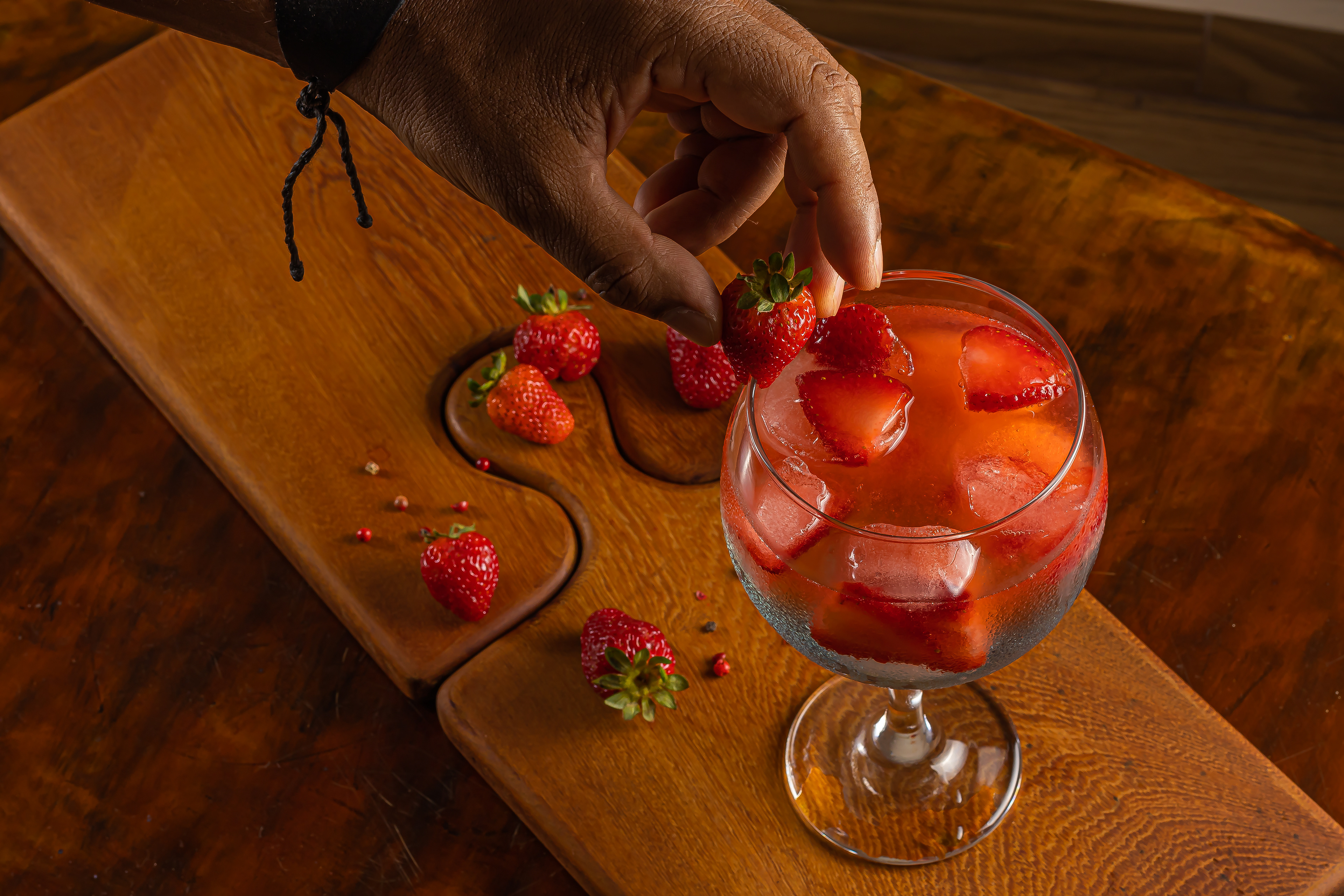 Foto colocando morango na borda do coquetel.