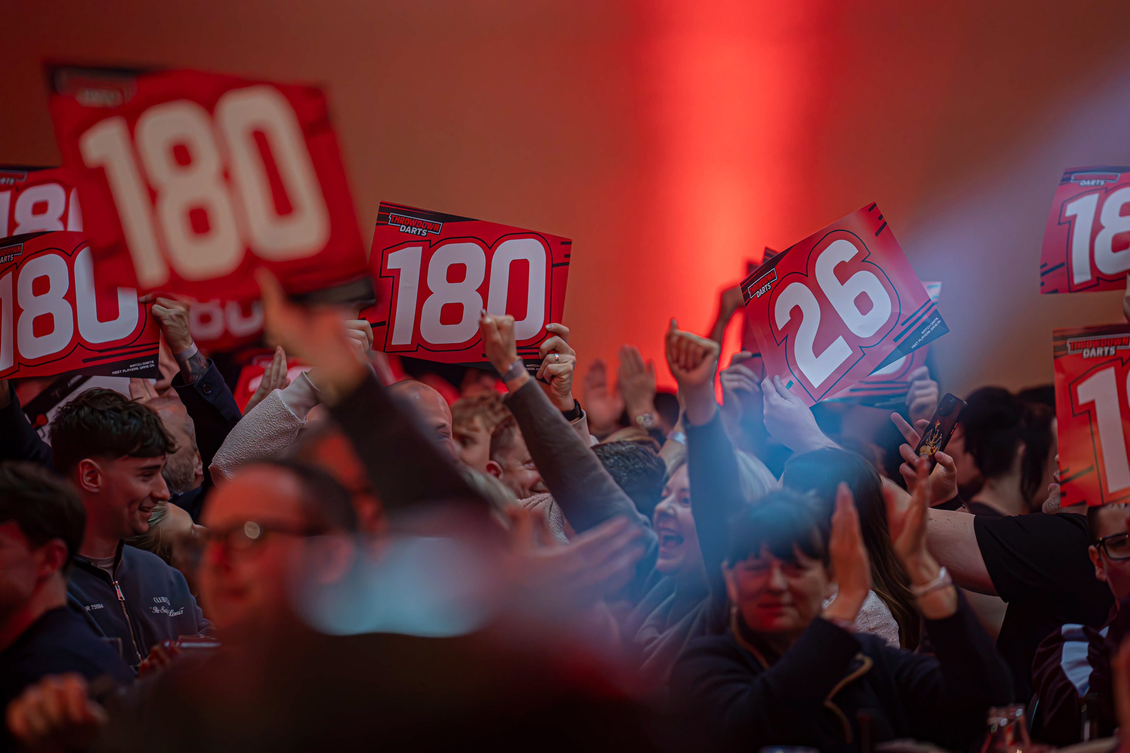 Fans of Throwdown Darts holding up their 180 scorecards as Damon Heta hits a 180 at the Copthorne Hotel, Brierley Hill. 27/03/26