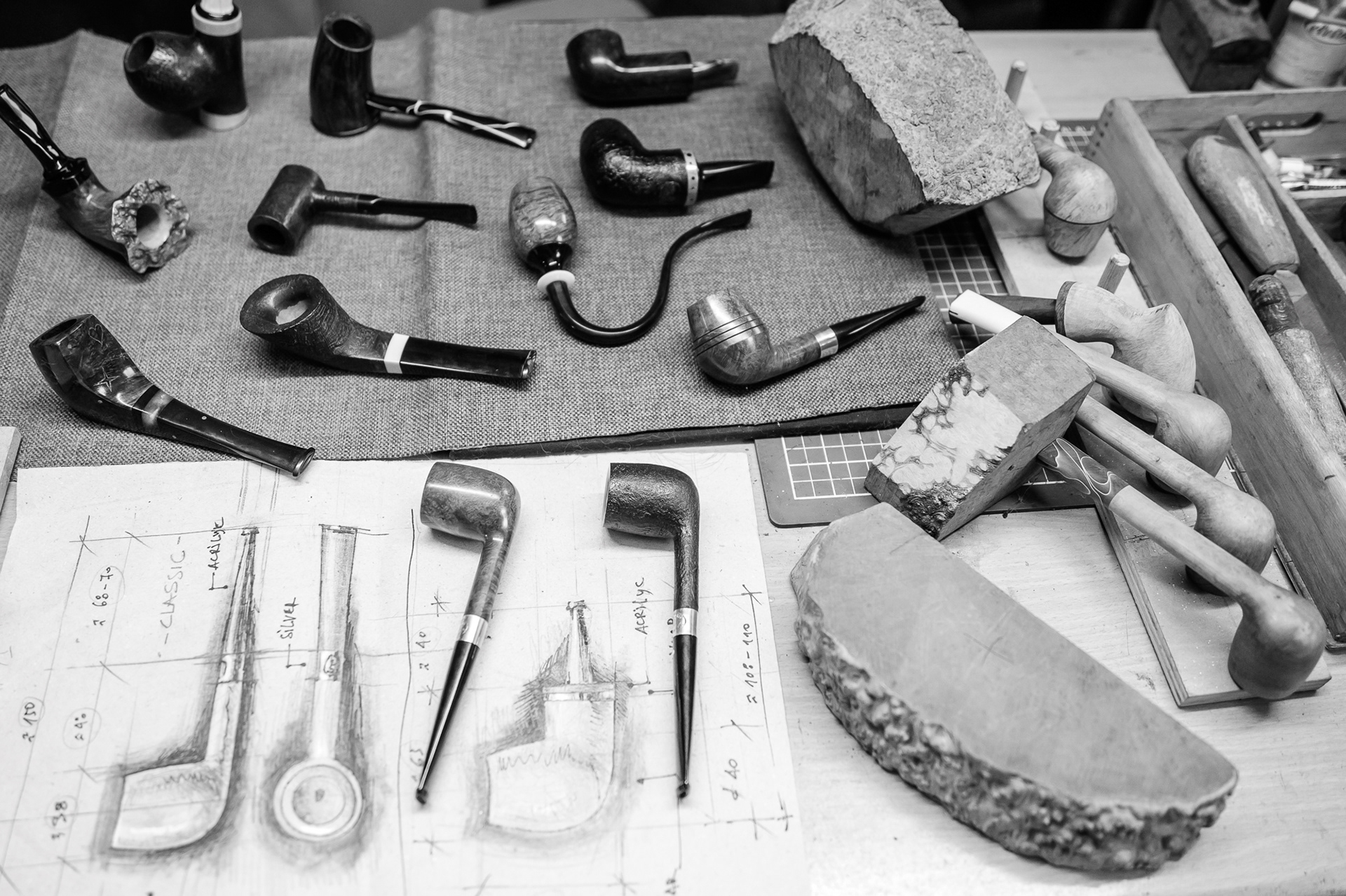 Finished tobacco pipes and some in progress, along with briar wood blocks and Getz sketches