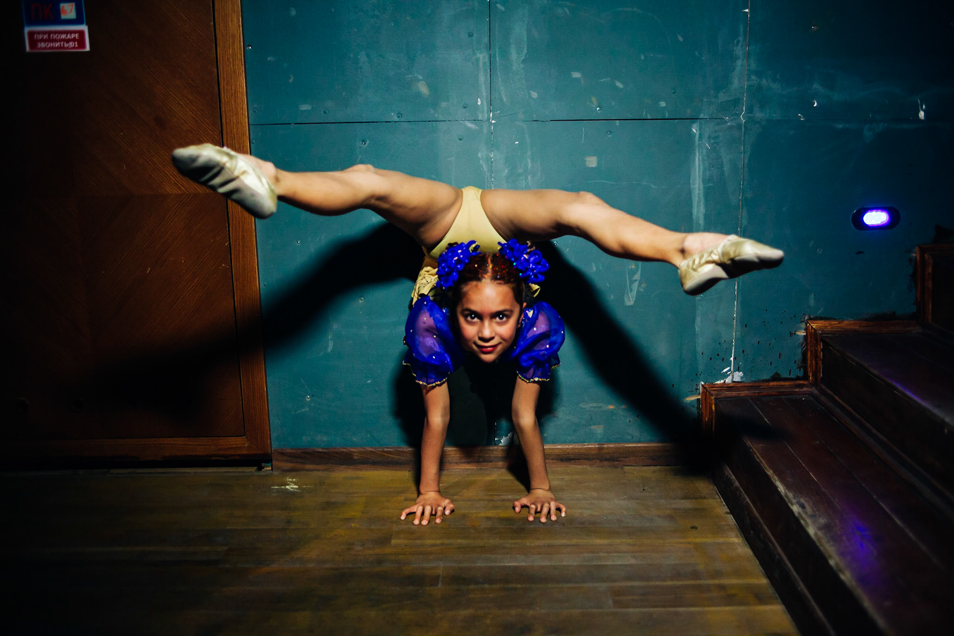 Model contest in Yalta.  Ukraine. A young girl is performing some circus moves inbetween the passage of the models. Yalta, Ukraine, May 2010.A journey through the eyes of Frederic Leonard, a head hunter for "new faces", who scouts fresh young Eastern girls who are to become fashion models. Yalta, Ukraine.Une petite fille me fait une figure de cirque en coulisses, pendant un défilé de jeunes mannequins en Ukraine (Yalta).
