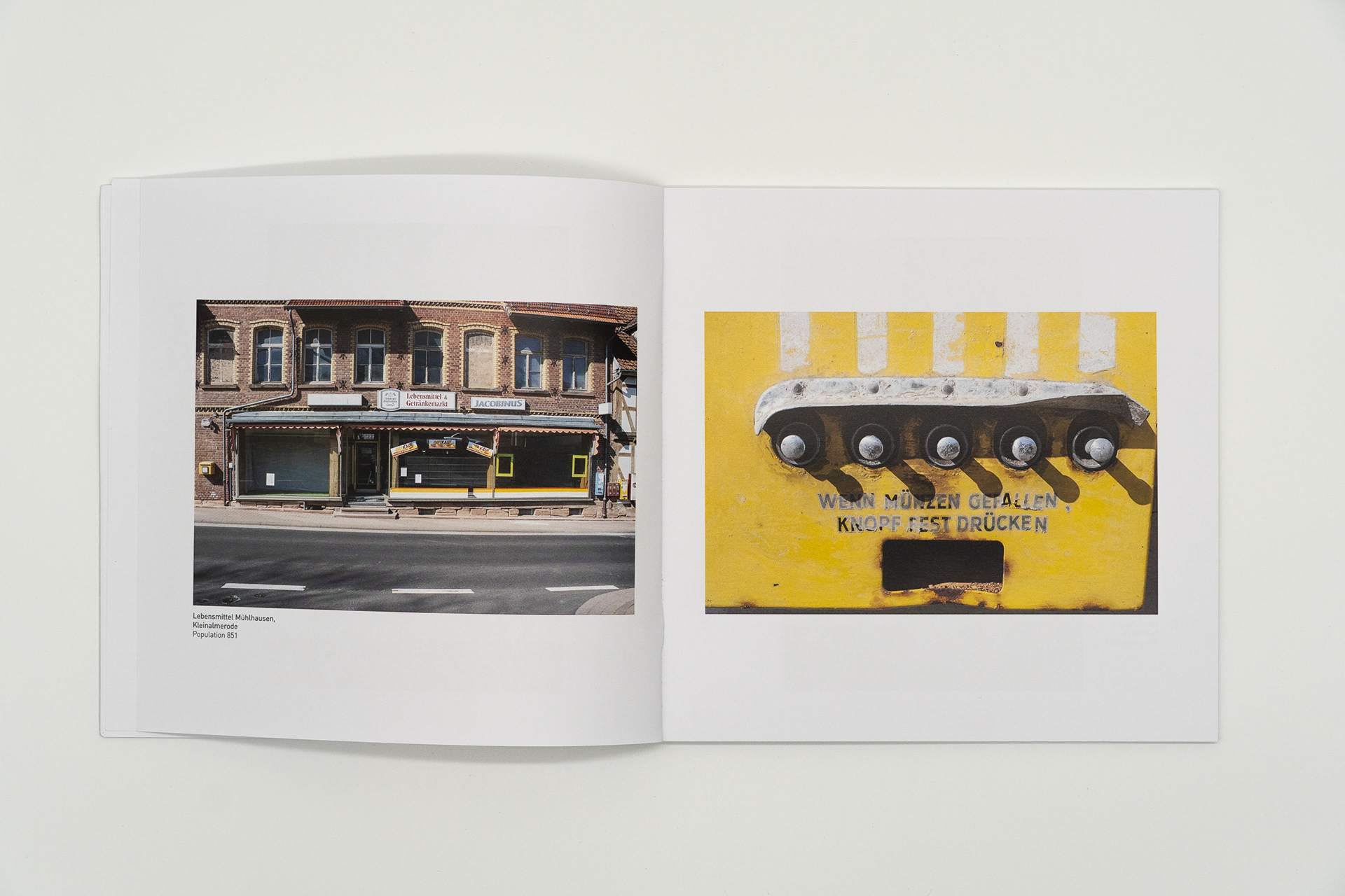 Aufgeschlagene Buchseite mit der Abbildung eines geschlossenen Dorfladens