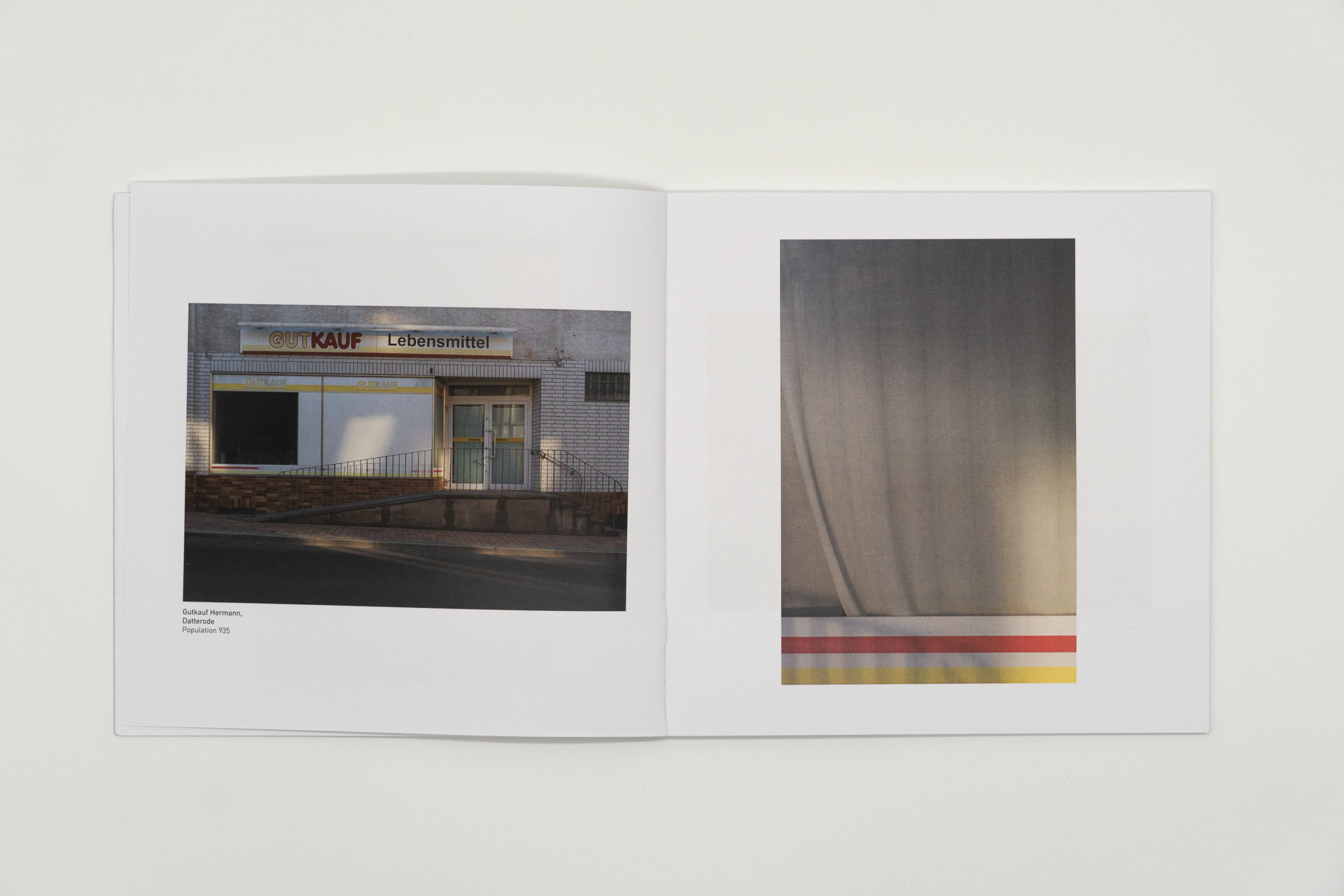 Aufgeschlagene Buchseite mit der Abbildung eines geschlossenen Dorfladens