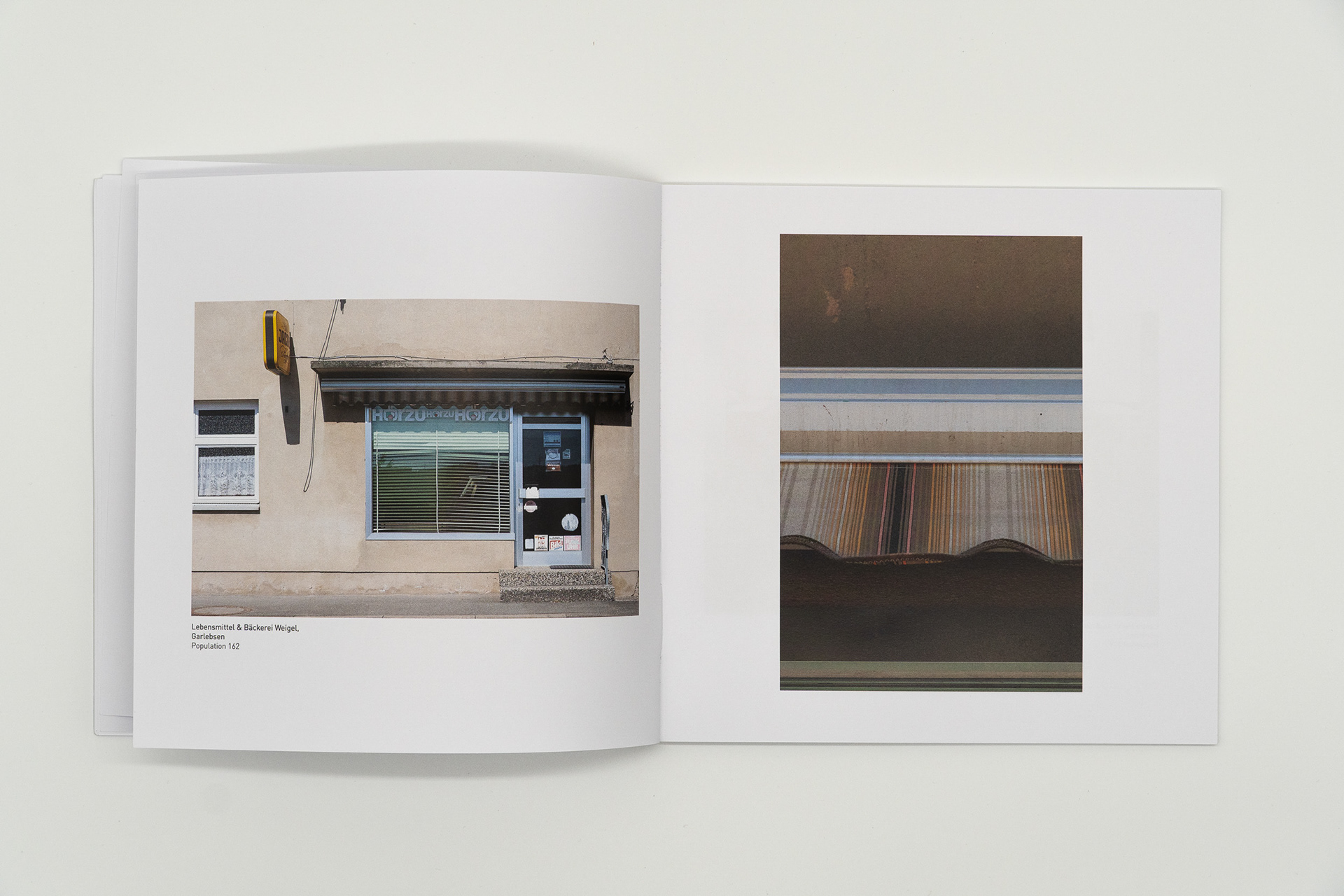 Aufgeschlagene Buchseite, die einen geschlossenen Dorfladen zeigt