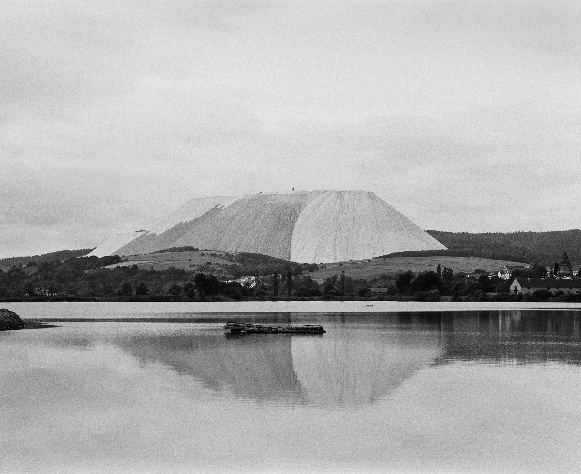 Kaliberg spiegelt sich in einem Kieswerksee