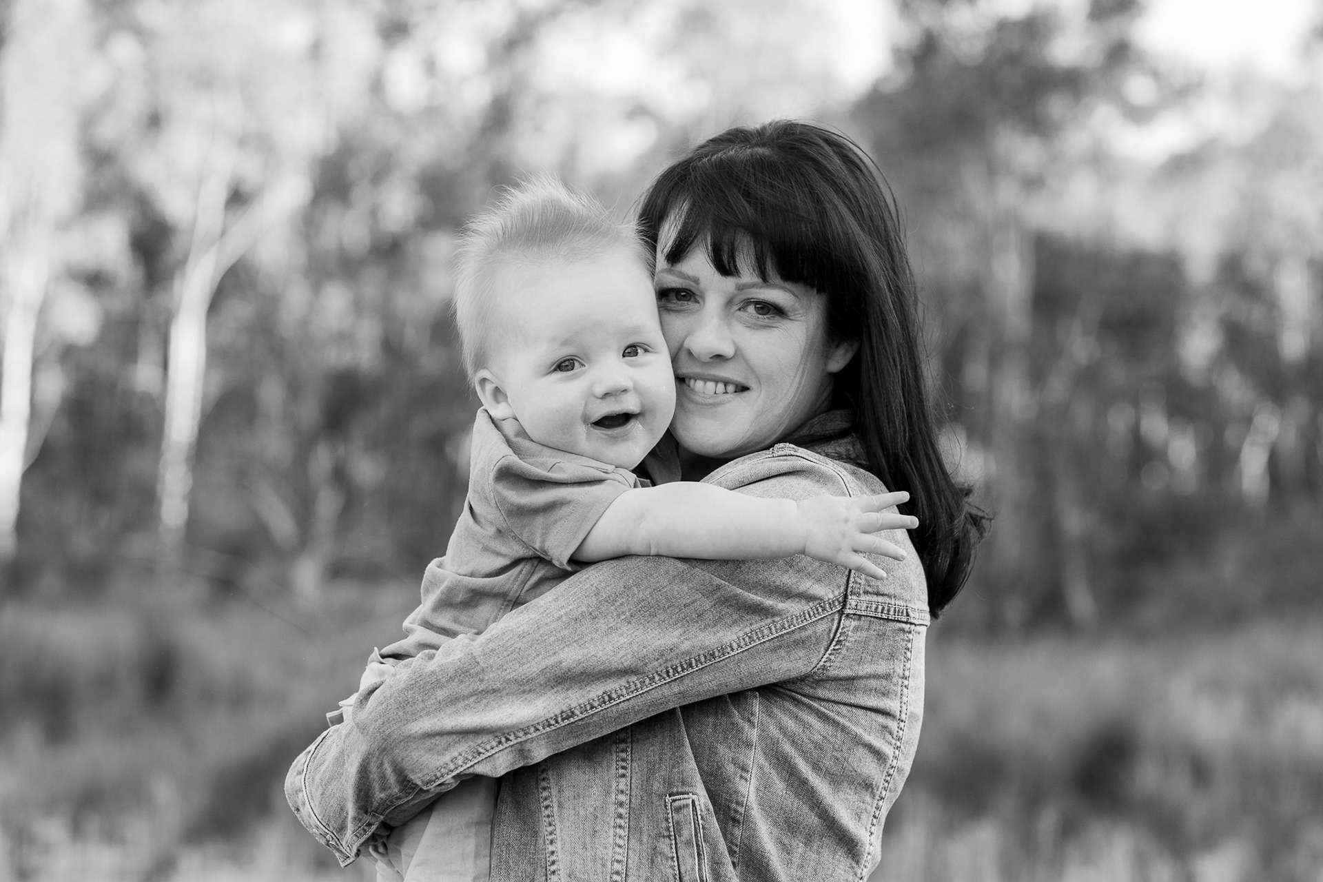 mother and baby smiling towards camera. Black and white image