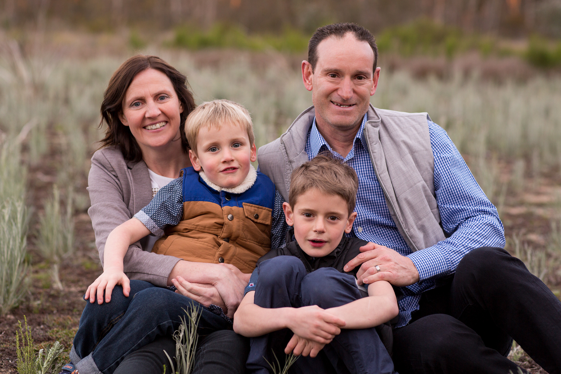 family photo of two parents with their two children smiling family