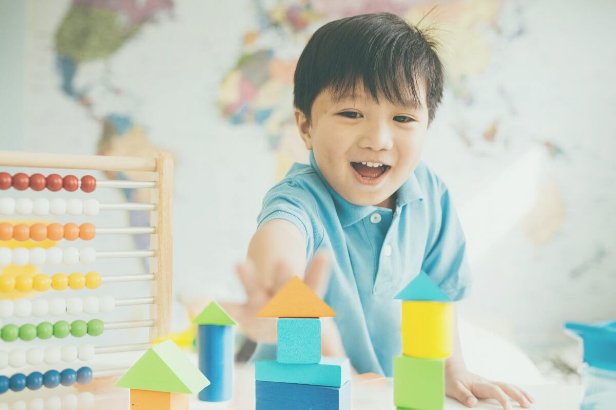 Photo of a boy excitedly playing with his toys