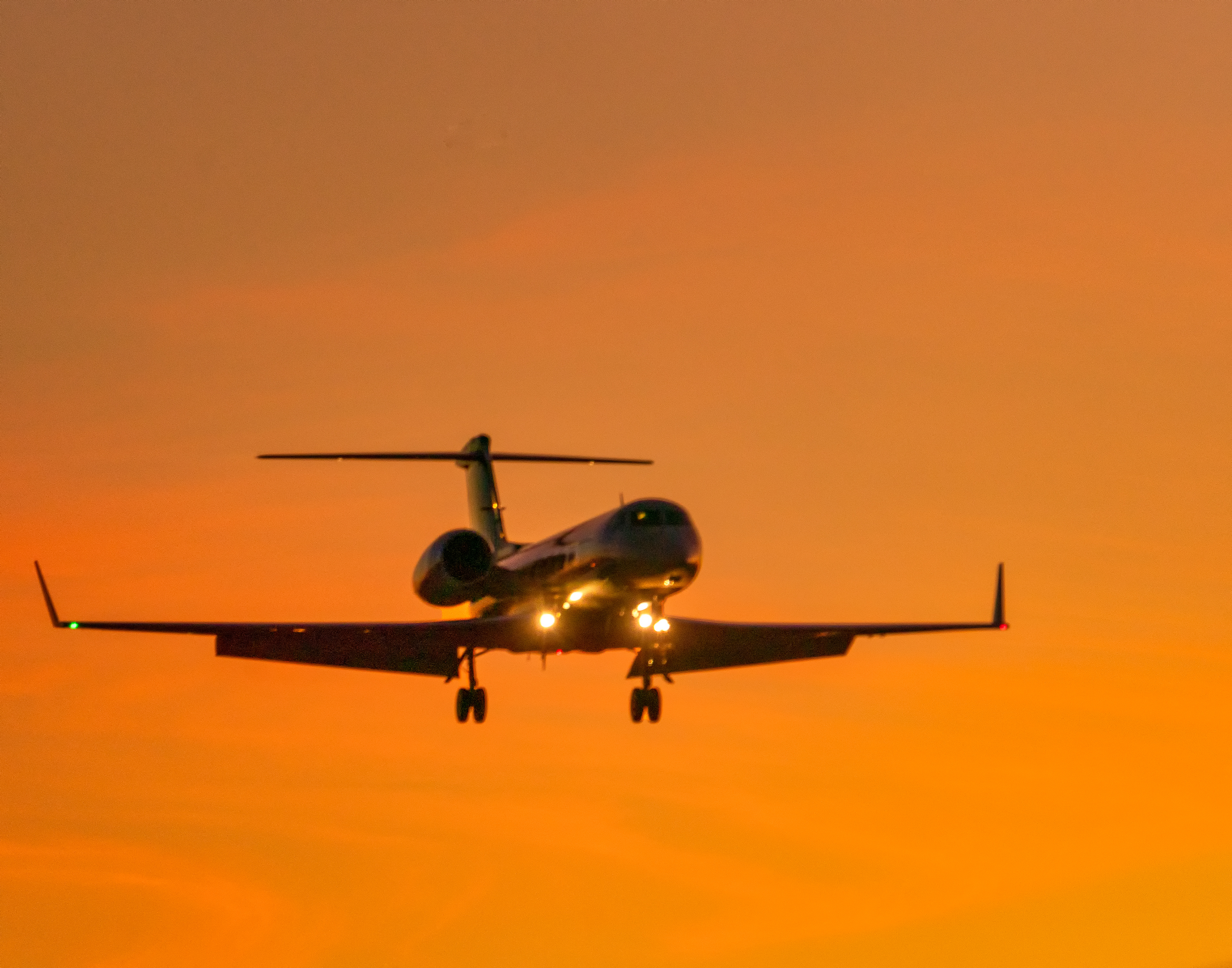 Final approach to land with a spectacular sunset as a background. Yes, I was next to the runway trying to manually focus to obtain better accuracy. Perfect weather for a landing.