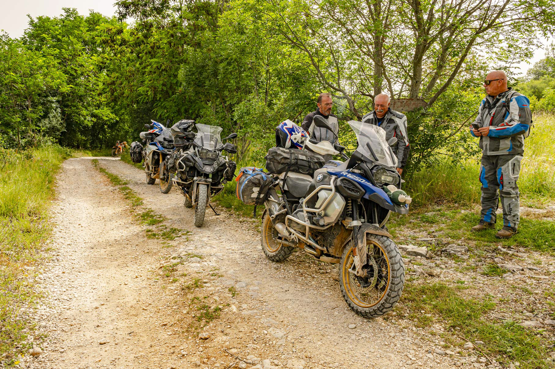 Petit groupe de motards en randonnée sur mesure, pause et convivialité, guidé par un photographe professionnel