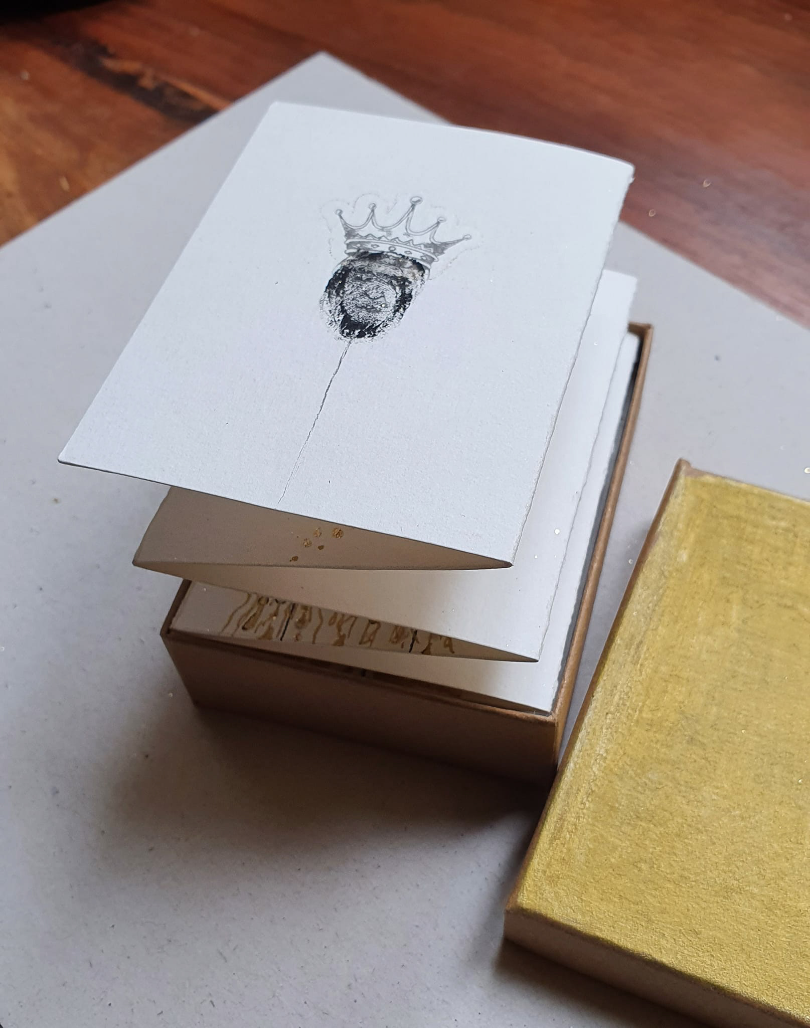 Livre d'artiste miniature composé de 10 dessins. Encre, posca, acrylique, tatouage malabar et feuille d'or sur papier canson 300g, 8.4×6,4 cm, dimension totale 115,2 × 8,4 cm. Dimensions de la boîte 6,6×8,6 cm. Cette réalisation n'attend plus que les poèmes de mon fidèle ami et poète Régis Roux. VENDU