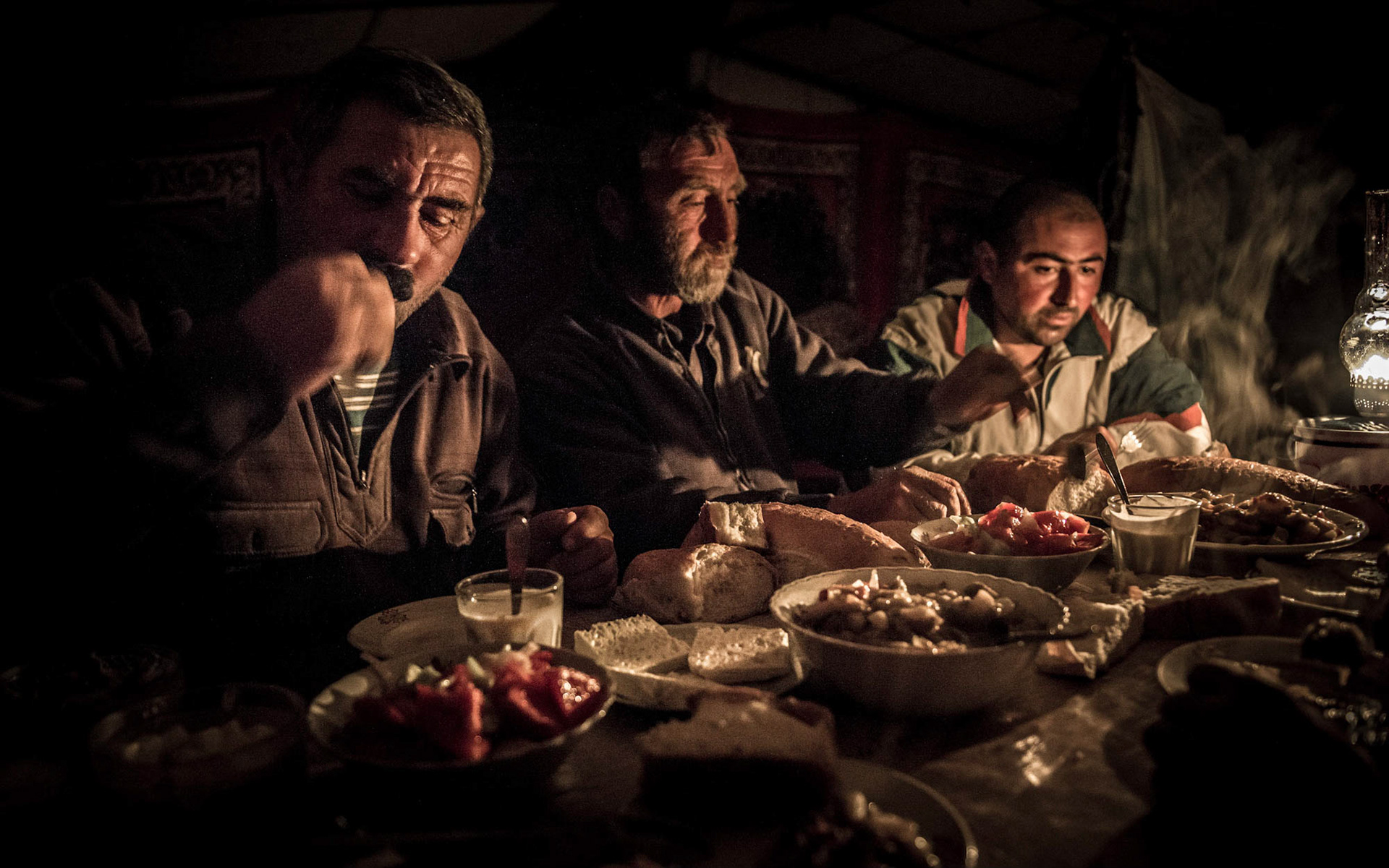 Shepherds in the high mountains of the Caucus Mountains in Georgia have their evening meal in the camp tent