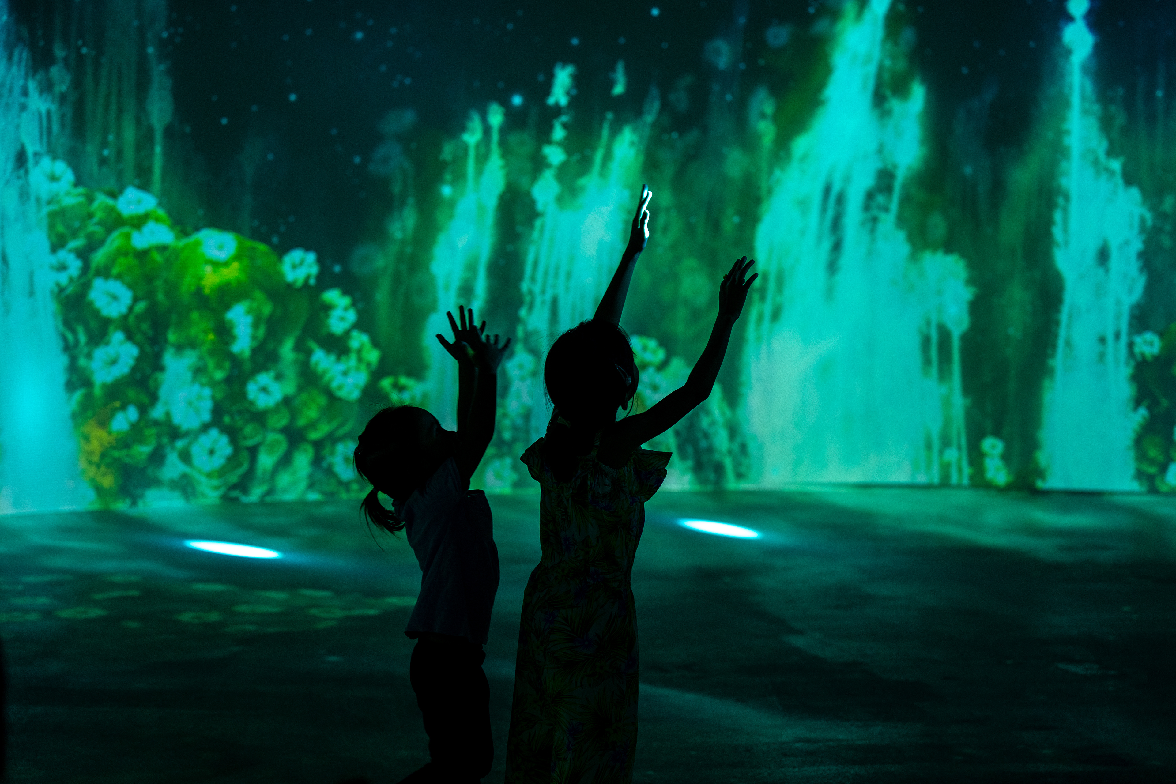 Two little girls playing with the lights of the 360° theatre show.