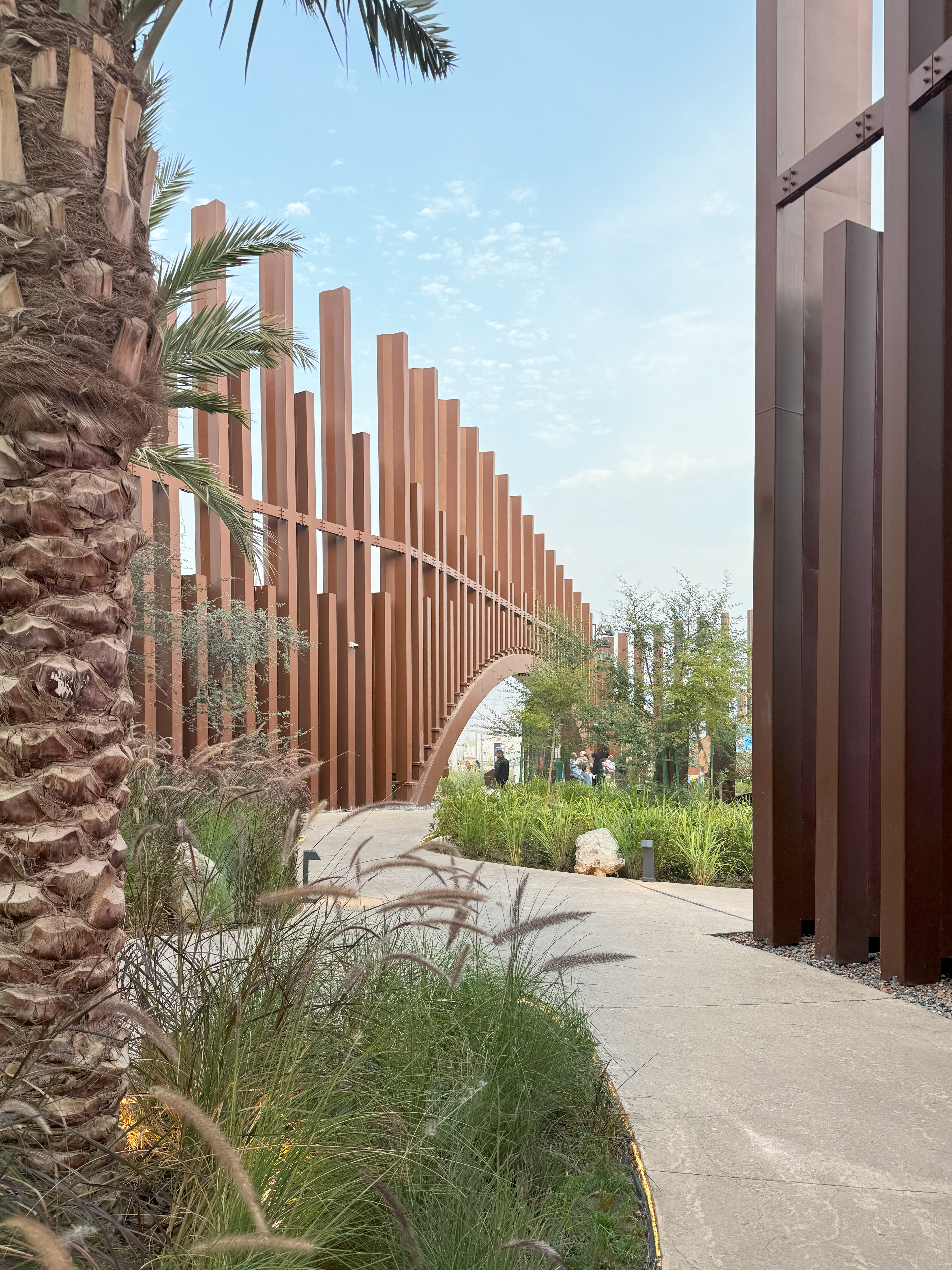 Internal lush garden with various species of Saudi Arabian plants, with the facade in the background
