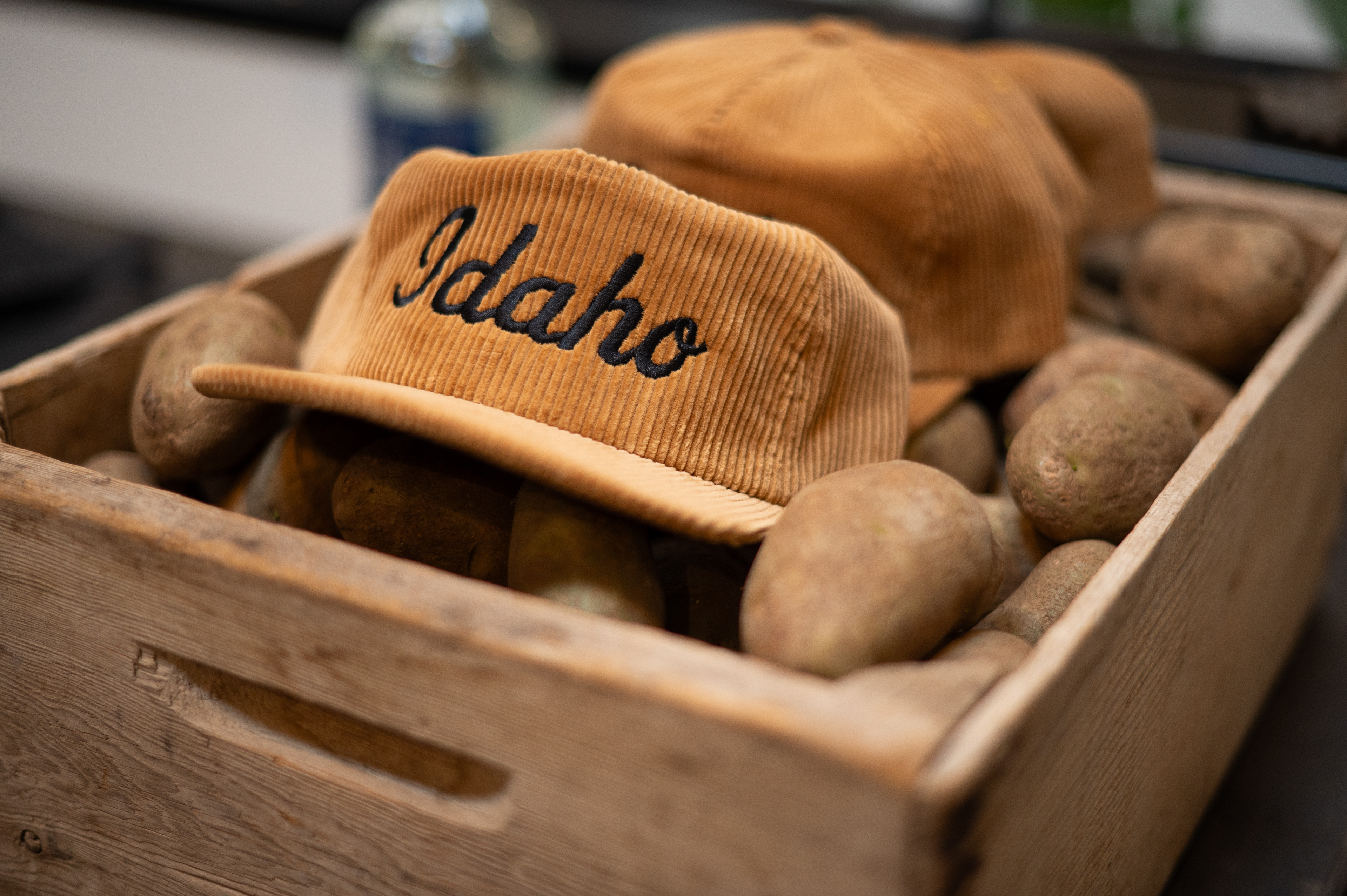 Corduroy Idaho embroidered hat sits atop a bin of potatoes at Gas & Grain vintage market in Coeur D'Alene. Store branding images follow.