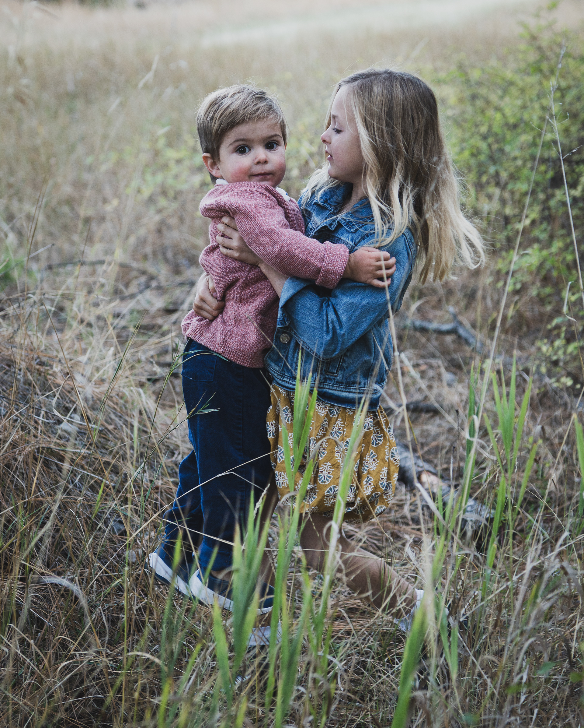 Big sister picking up little brother