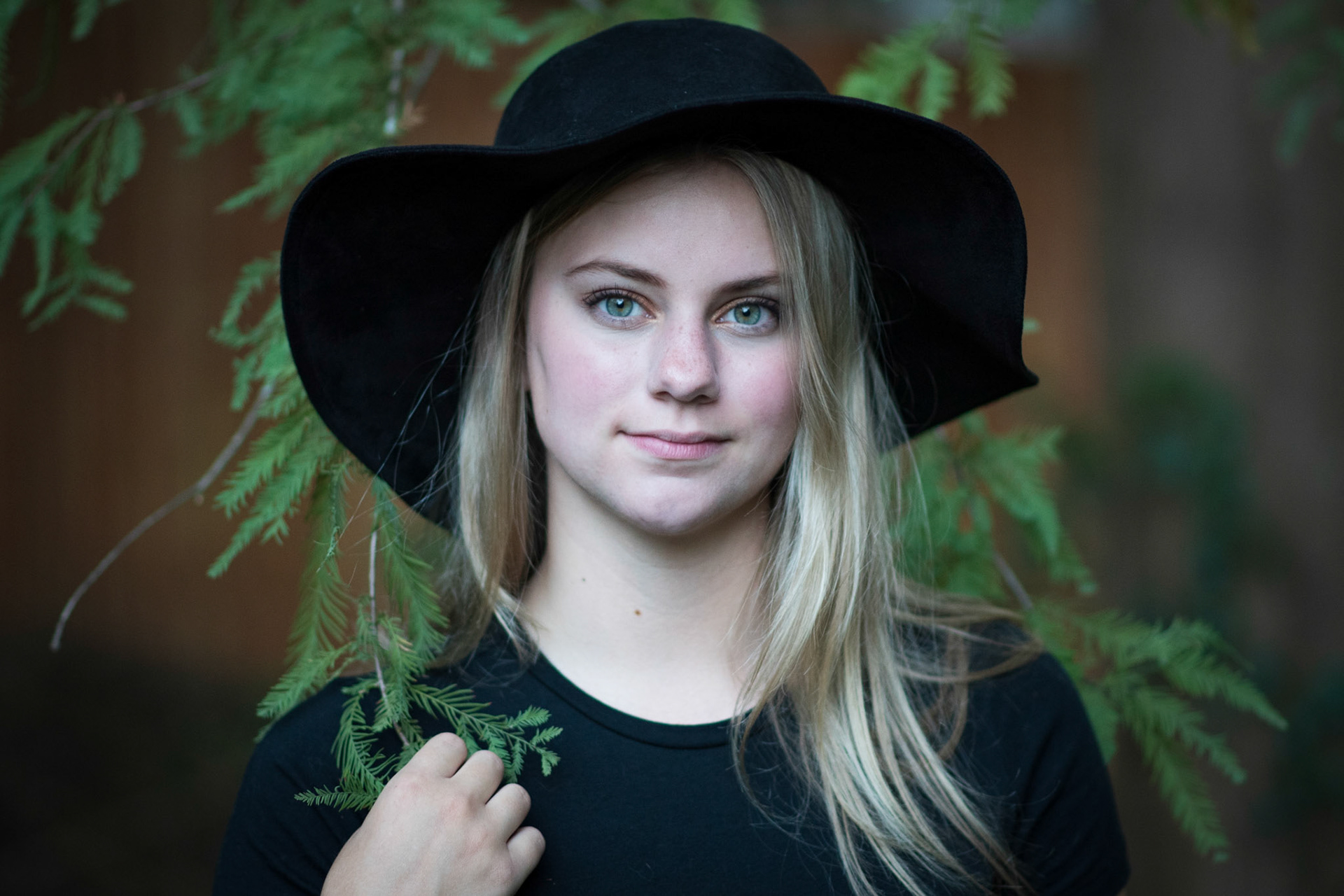high school senior girl with black hat and green eyes