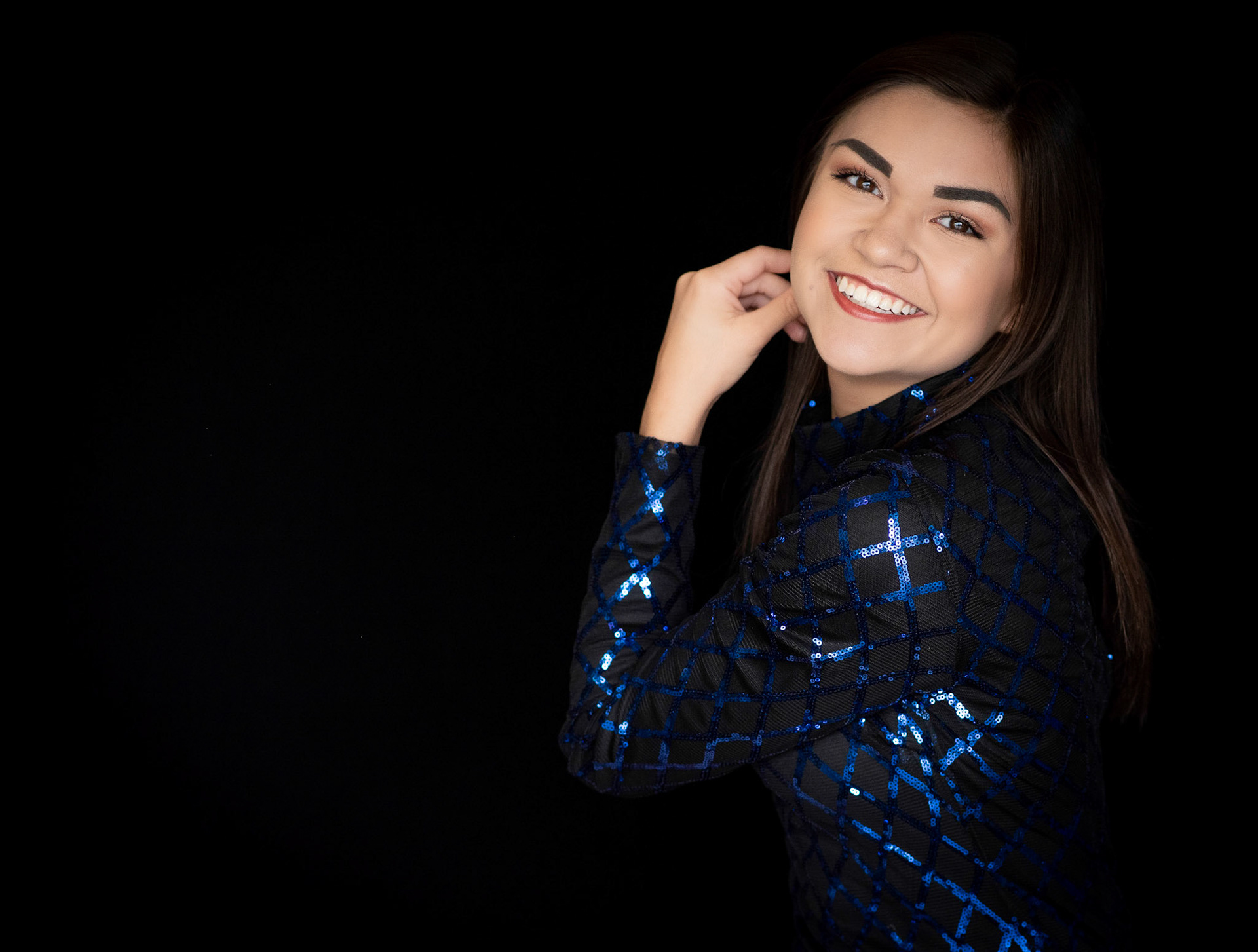 high school senior girl with dark hair and eyes in sparkling blue.