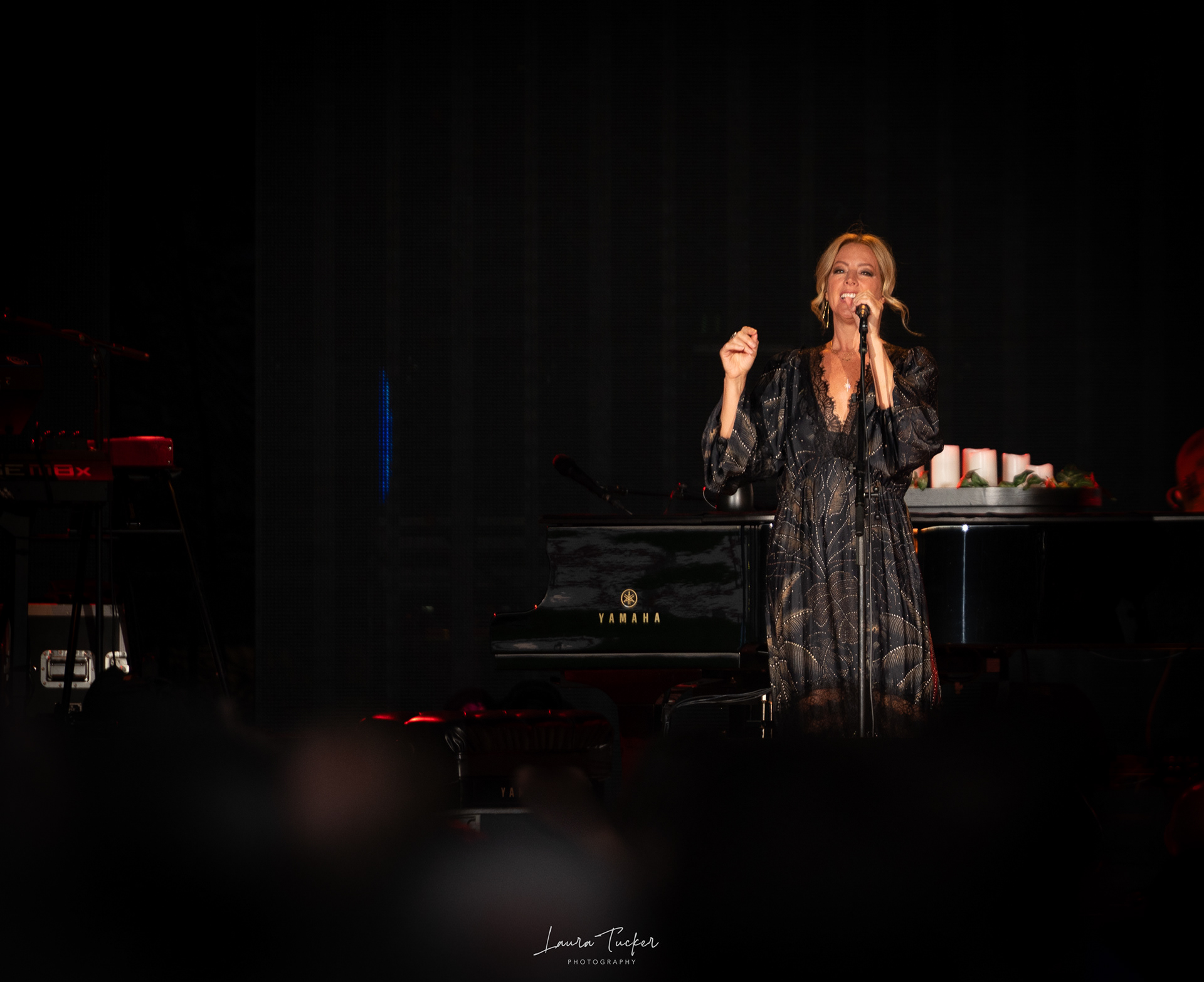 Sarah McLachlan performing on stage in a black dress.