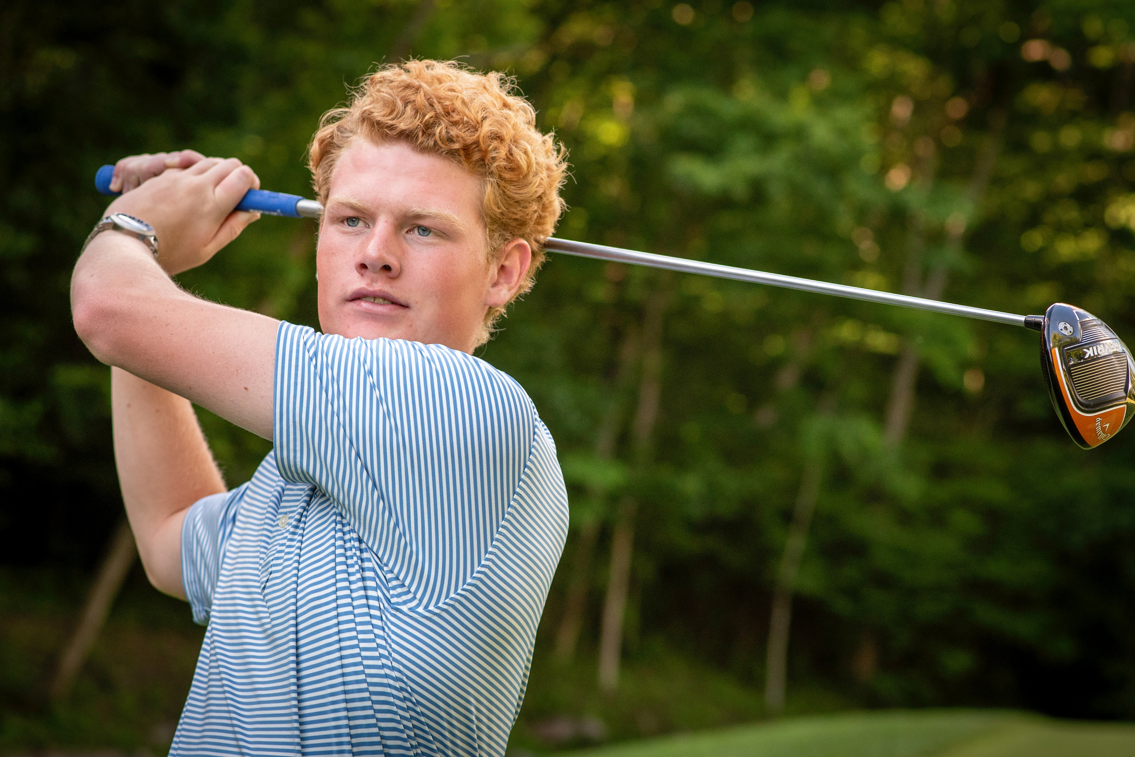 high school senior boy with red hair golfing