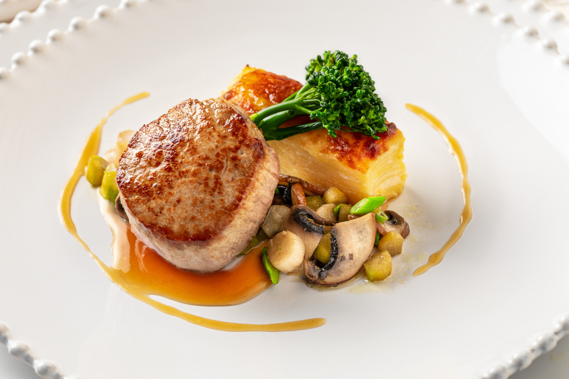 Medalhão de vitelinha com batata gratinada, espargos e cogumelos shitaki