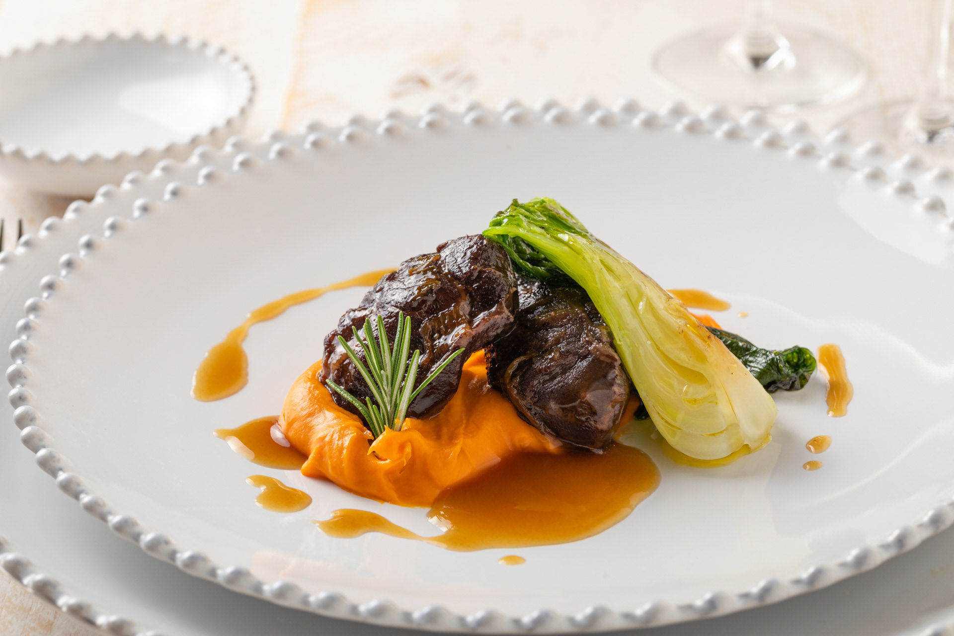 Bochecha de porco com pure de batata doce e pack-choy fotografia comida