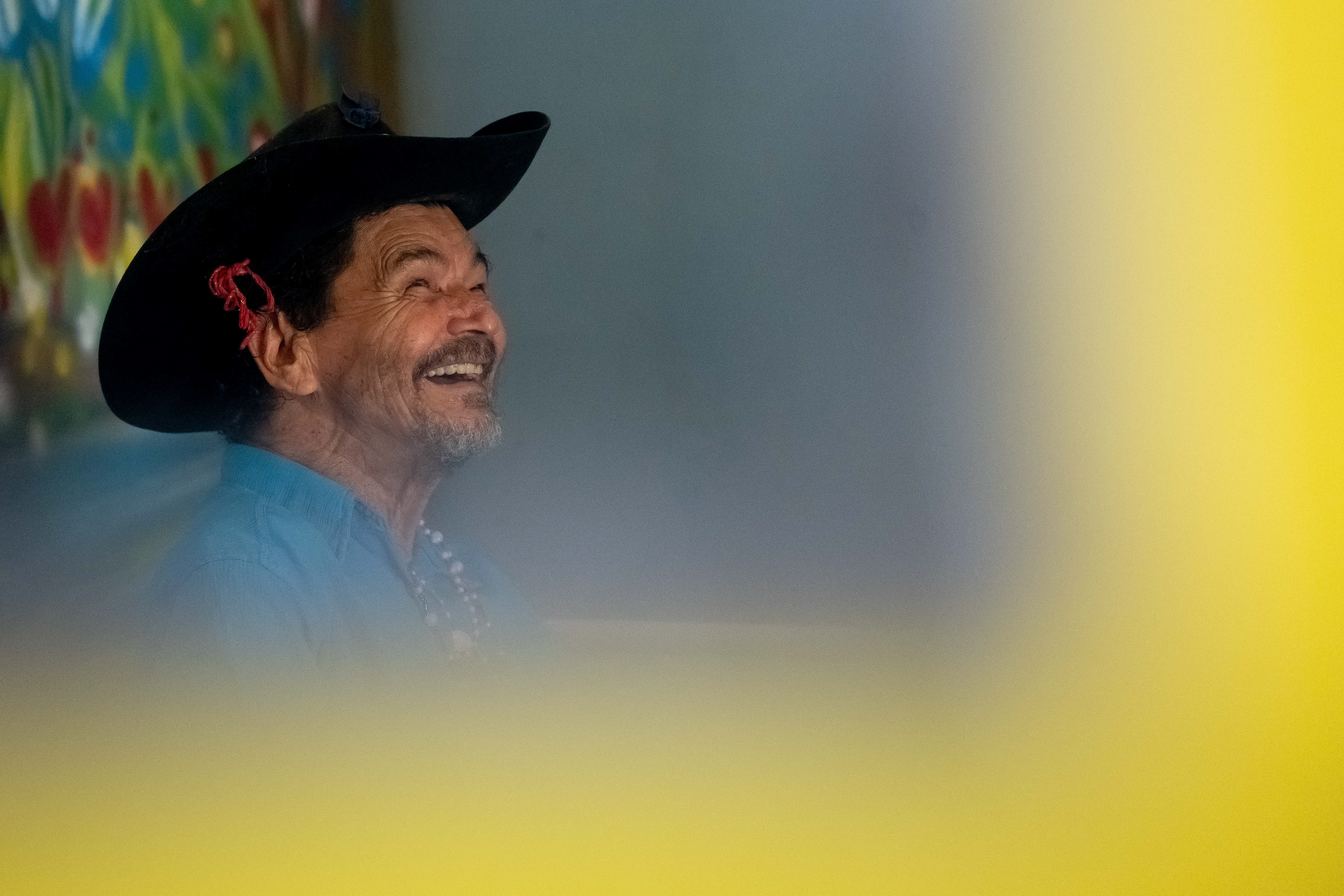 Pipa laughs in his room at the Saint Vincent de Paul Home in Cidade de Goiás, Go., Friday, March 6, 2026. Living with an intellectual disability, he often turns to music as a way to spend his time. (© Camden Hall)
