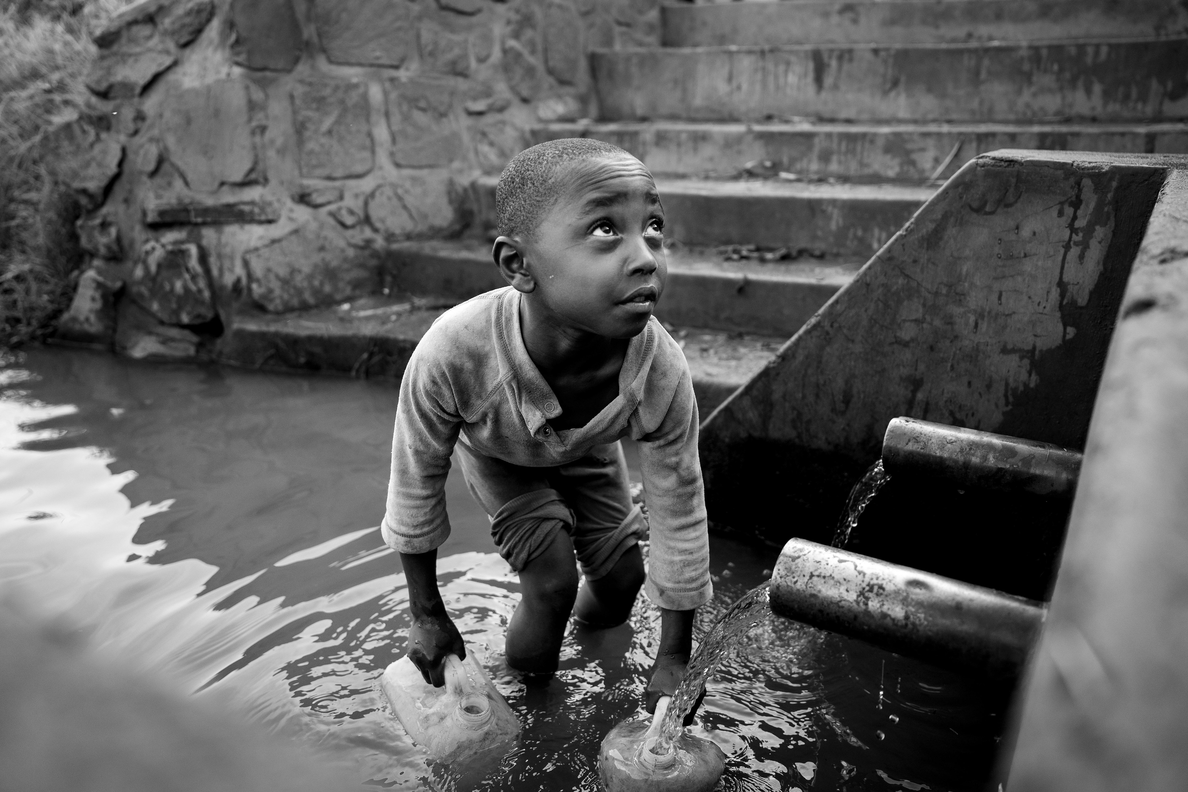 A young boy fills up a canister with water from the local well near the Murindi Villiage in Kigali, Rwanda, Monday, March 3, 2025.