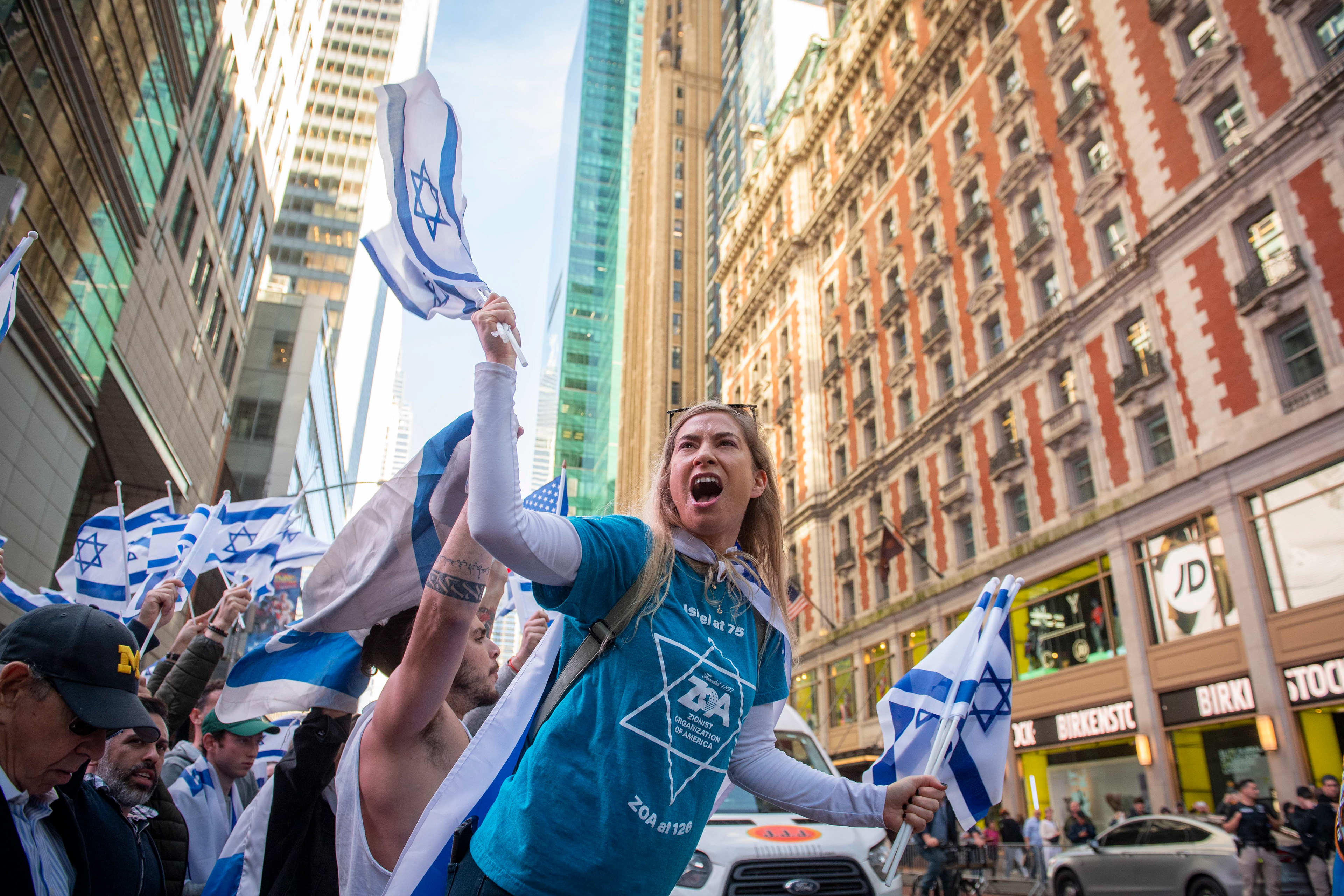 A woman waves Israel flags and yells towards the pro-Palestine rally during what is being called the "international day of action for Palestine" Thursday, Oct. 13, 2023, in New York, N.Y.