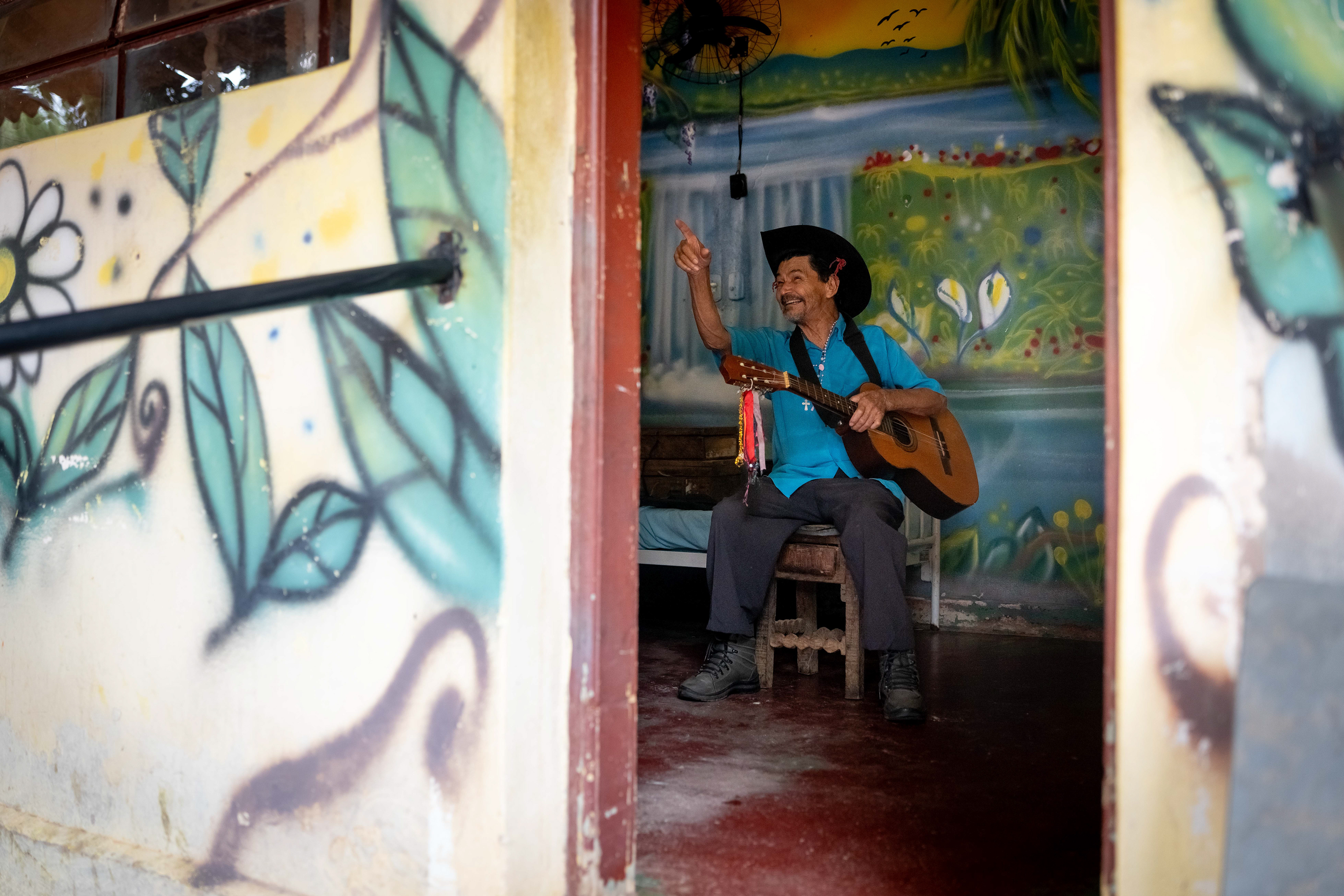 Pipa plays his guitar in his room at the Saint Vincent de Paul Home in Cidade de Goiás, Go., Friday, March 6, 2026. Living with an intellectual disability, he often turns to music as a way to spend his time. (© Camden Hall)