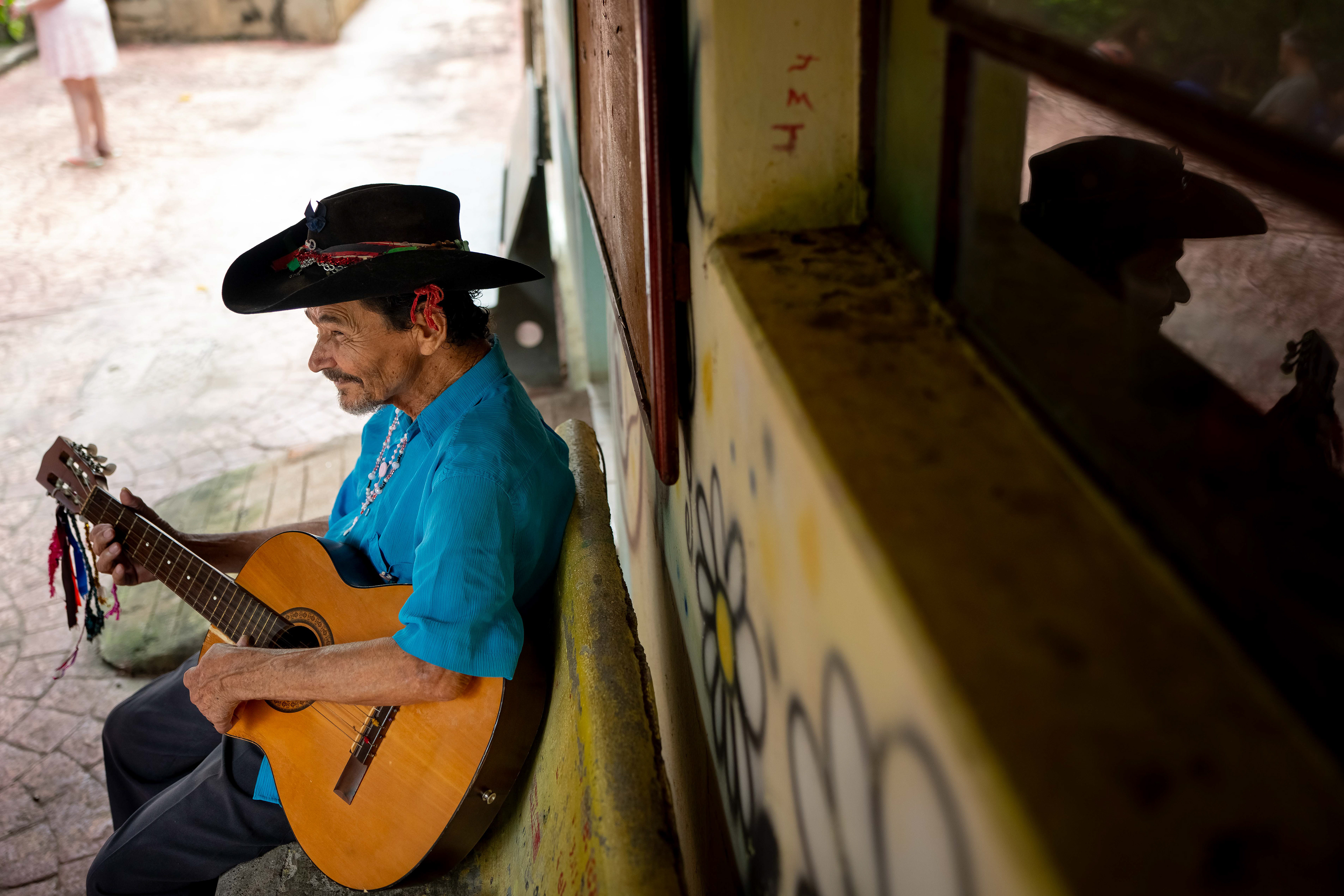 Pipa plays his guitar outside of his room at the Saint Vincent de Paul Home in Cidade de Goiás, Go., Friday, March 6, 2026. Living with an intellectual disability, he often turns to music as a way to spend his time. (© Camden Hall)